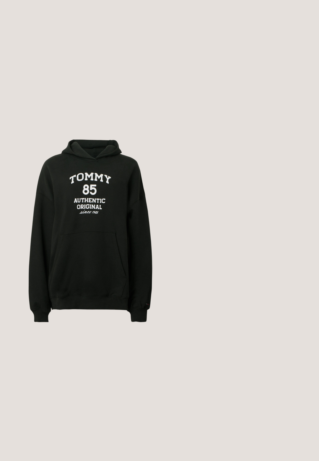 Čierna mikina s kapucňou z mäkkej látky s klokanie vrecko. Na prednej strane je biely nápis: „TOMMY 85 AUTHENTIC ORIGINAL since 1985".; Biela bavlnená tričko s kurzívou, lesklým ružovo-zlatým logom "Hugo" na prednej strane. Štandardný okrúhly výstrih a krátke rukávy.; Modré široké džínsové nohavice z denimu s vyblednutým efektom a roztrhnutým otvorom na ľavom stehne, vybavené prednými vreckami a zapínaním na gombík.; Biele športové tenisky s hrubou podrážkou, na boku s logom v červenej, bielej a modrej farbe a hladkým koženým povrchom.; Krémsová kožená hobo taška s jedným nastaviteľným ramenným popruhom a horným zipsovým zatváraním na bielom pozadí.; Strieborné kovové kruhové náušnice s hladkým, mierne zakriveným povrchom a zapínaním na poistku na jednoduchom bielom pozadí.