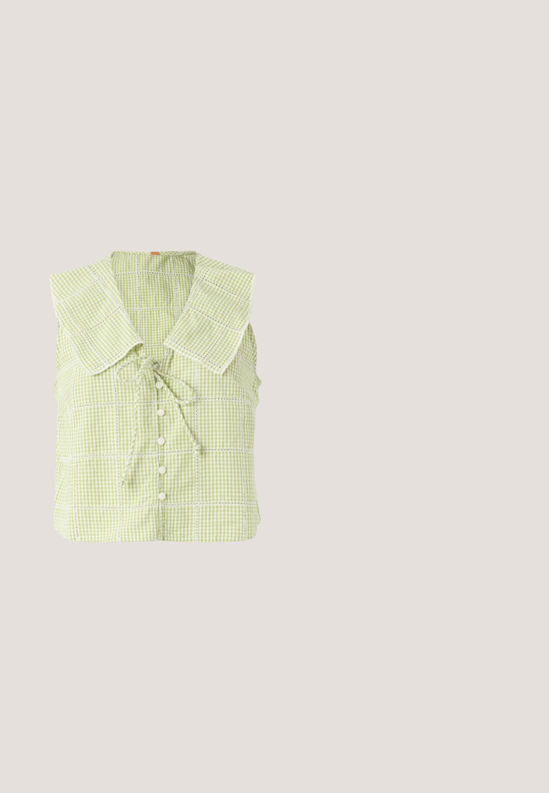 Blouse sans manches vichy vert clair avec grand col carré, boutons sur le devant et un nœud noué au niveau de l'encolure.; Short vichy jaune et blanc avec taille élastique, coupe décontractée et ouvertures de jambes droites.; Baskets dorées avec des bandes blanches et une fermeture Velcro. Fini métallique lisse, bout arrondi et semelle en caoutchouc texturée.; Lunettes de soleil rectangulaires en écaille avec des montures épaisses et des verres teintés marron posées sur une surface blanche.; Sac fourre-tout vert avec un tissu texturé et froissé et de larges poignées, présenté sur un fond clair uni.; Barrette en écaille en plastique brillant, présentant une forme incurvée et huit dents de préhension pour une tenue sûre.
