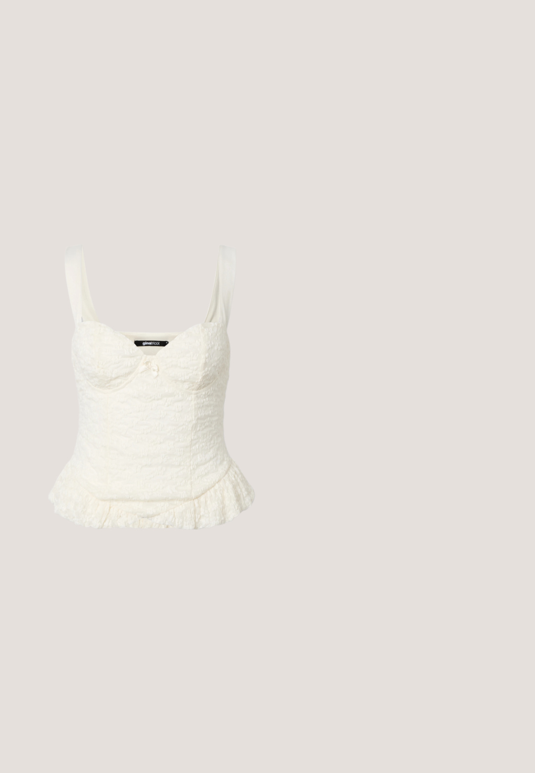 Haut sans manches blanc texturé pour femmes avec encolure sweetheart, corsage ajusté, petit détail de nœud et ourlet à volants.; Mini jupe en denim bronze métallisé avec une coupe droite, poches avant et une taille avec fermeture à bouton. Texture lisse et brillante.; Botte noire haute jusqu'au genou avec bout pointu, petit talon kitten et finition en cuir brillant à texture crocodile.; Lunettes de soleil hexagonales teintées or avec des branches blanches et un fin pont en métal doré reposant sur une surface blanche.; Sac à bandoulière en cuir noir avec deux poches zippées, détails en métal doré et une large sangle réglable. Texture lisse et forme rectangulaire.; Boucles d'oreilles créoles dorées avec une surface lisse et polie. Forme circulaire présentant une ouverture, mettant en valeur un design moderne.
