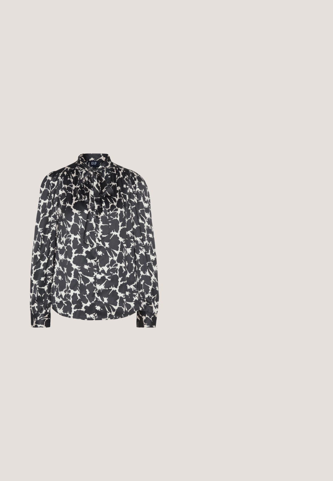 GAP TIE NECK - Blusa - black; Leggings negros con cintura alta, que presentan cuatro botones metálicos en la parte frontal. Fabricados con material elástico, tienen un diseño ceñido y elegante.; Zapato de tacón alto de ante negro con punta afilada, textura suave y tacón de aguja delgado. Diseño clásico con una silueta elegante.; Gafas de sol negras y angulares con lentes grises; fabricadas en plástico, con varillas gruesas de superficie suave y sin herrajes visibles.; Bolso estructurado negro de cuero con un asa superior, correa de hombro desmontable y un detalle de tapa en la parte frontal. Acentos en dorado.; Pendientes de aro en tono dorado con un diseño ondulado, que incluyen un acento de perla blanca colgante. La textura es suave y los aros son ligeros.