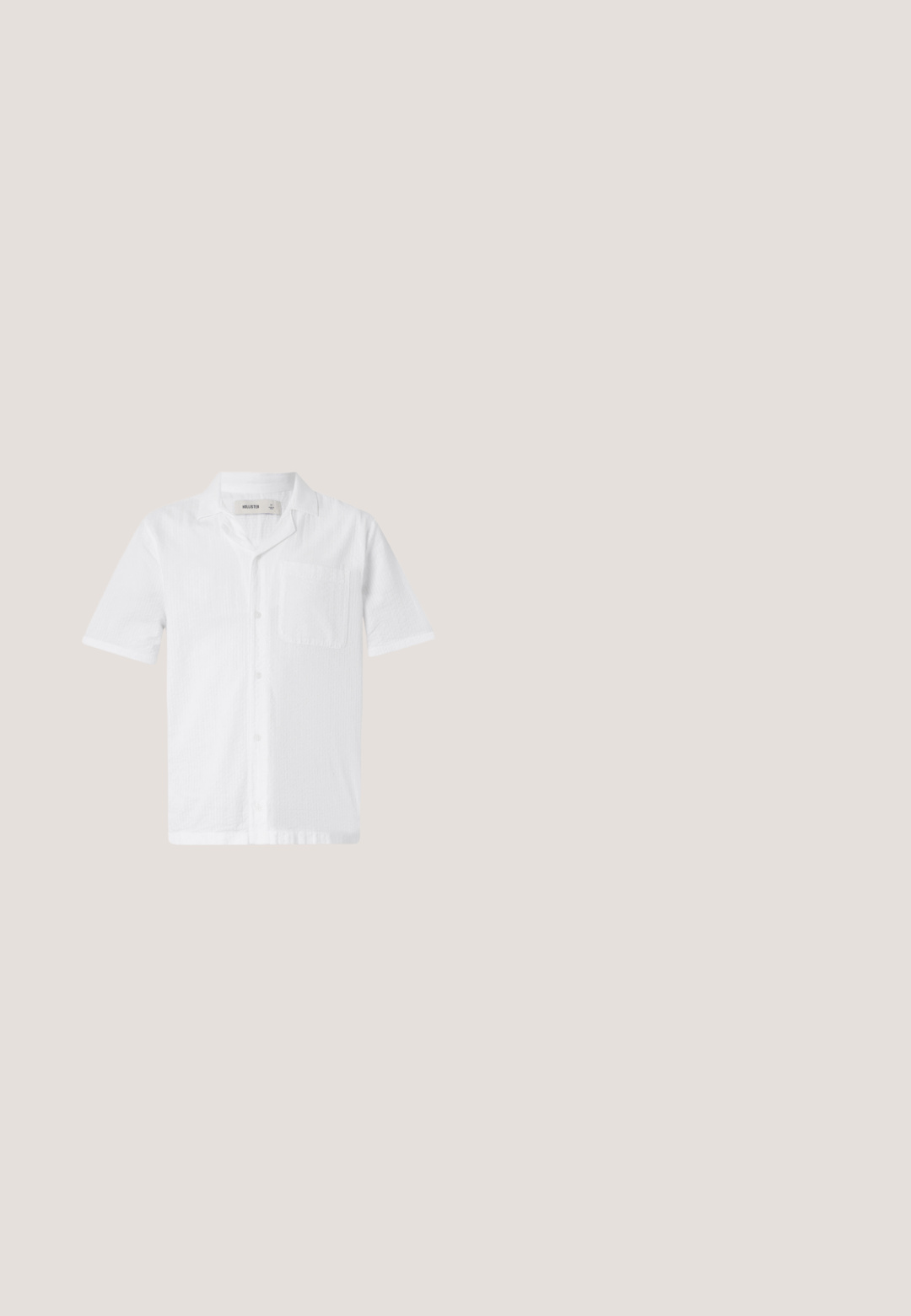 Camisa blanca de botones de manga corta con un bolsillo, que presenta una tela texturizada y un diseño de cuello relajado.; Pantalones cortos de algodón beige con un diseño de frente plano, cierre de un solo botón y puños doblados. Presenta bolsillos laterales y una textura suave.; Sandalia deslizante de tiras cruzadas en color marrón con acabado mate, suela negra plana y textura suave. Diseño minimalista sin herrajes visibles.; Gafas de sol carey con montura cuadrada, lentes verdes degradados y detalles metálicos en las varillas. Material plástico suave.; Bolsa tote de lona color crema con bolsillo delantero, dos asas, correa de hombro ajustable y pequeño texto amarillo "O.N.S" en la parte inferior derecha del bolsillo.; Cinturón de tela trenzada verde oliva con extremo de cuero marrón y hebilla metálica rectangular plateada, enrollado sobre un fondo blanco.