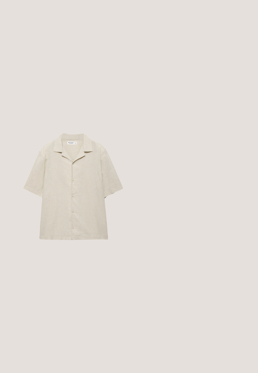 Chemise beige à manches courtes avec boutons et col campagnard, fabriquée en tissu léger, présentée à plat sur un fond blanc.; Shorts en denim bleu clair à coupe droite, avec poches avant, fermeture à bouton et couture décontractée. Texture lisse sans motifs.; Sandales en cuir marron avec deux larges brides et une boucle de cheville réglable. Caractéristiques : semelle plate et semelle extérieure en caoutchouc noir texturé.; Lunettes de soleil Ray-Ban avec des verres verts, monture en plastique noir et accents dorés sur les bords. Forme carrée avec une finition mate.; Sac fourre-tout en toile crème avec poche avant, deux poignées, bandoulière réglable et petit texte jaune "O.N.S" en bas à droite de la poche.; Ceinture tressée en tissu beige avec boucle métallique argentée et détails en cuir marron, comprenant un patch logo cousu à l'extrémité.
