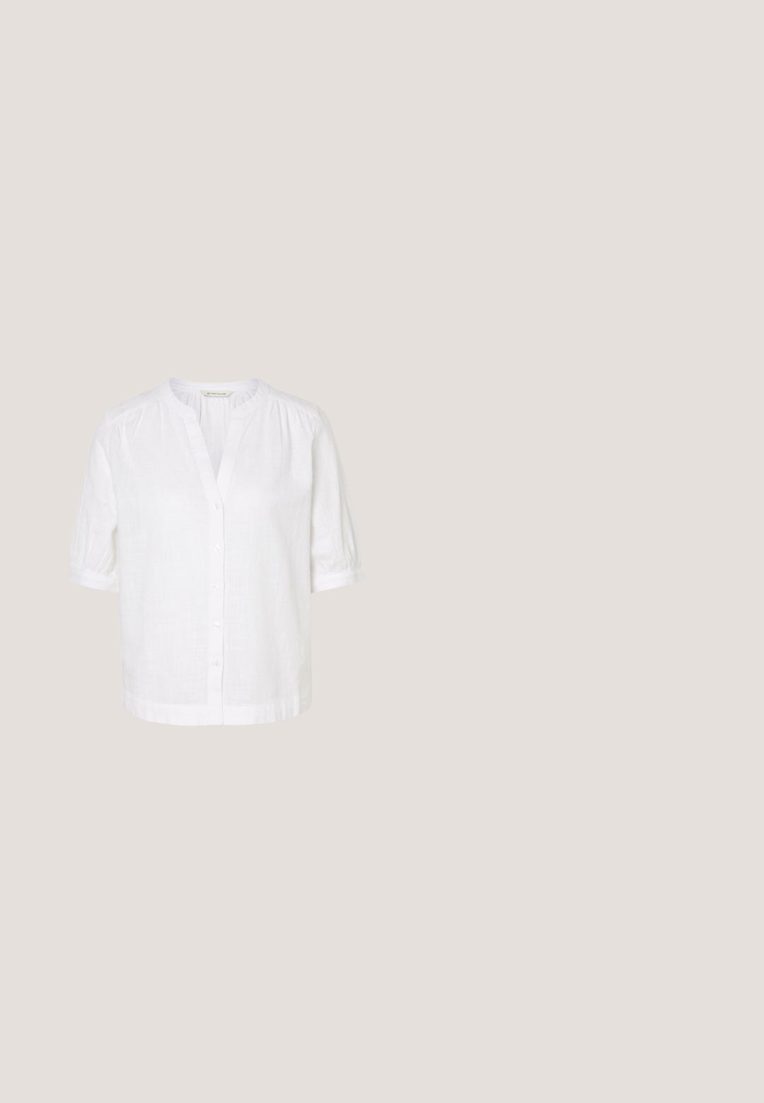 Blouse blanche manches courtes à col mandarin, boutonnée sur le devant, avec légères fronces aux épaules et aux poignets.; Jeans en denim foncé évasés avec une taille haute, deux poches avant et des coutures orange. Le matériau semble robuste et lisse.; Chaussure Mary Jane noire avec talon carré et sangle à boucle dorée, flottant au-dessus d'un sol en béton lisse dans un cadre intérieur minimaliste.; Lunettes de soleil rondes teinte brun avec une monture bordeaux brillante. Branches fines avec un détail de marque subtil. Design de verres plats.; Sac fourre-tout noir en simili cuir avec une finition texturée, deux longues poignées et des accents en métal doré sur le côté. Shape rectangulaire.; Ceinture en cuir noir enroulée avec une boucle en métal doré brillant sur un fond clair.