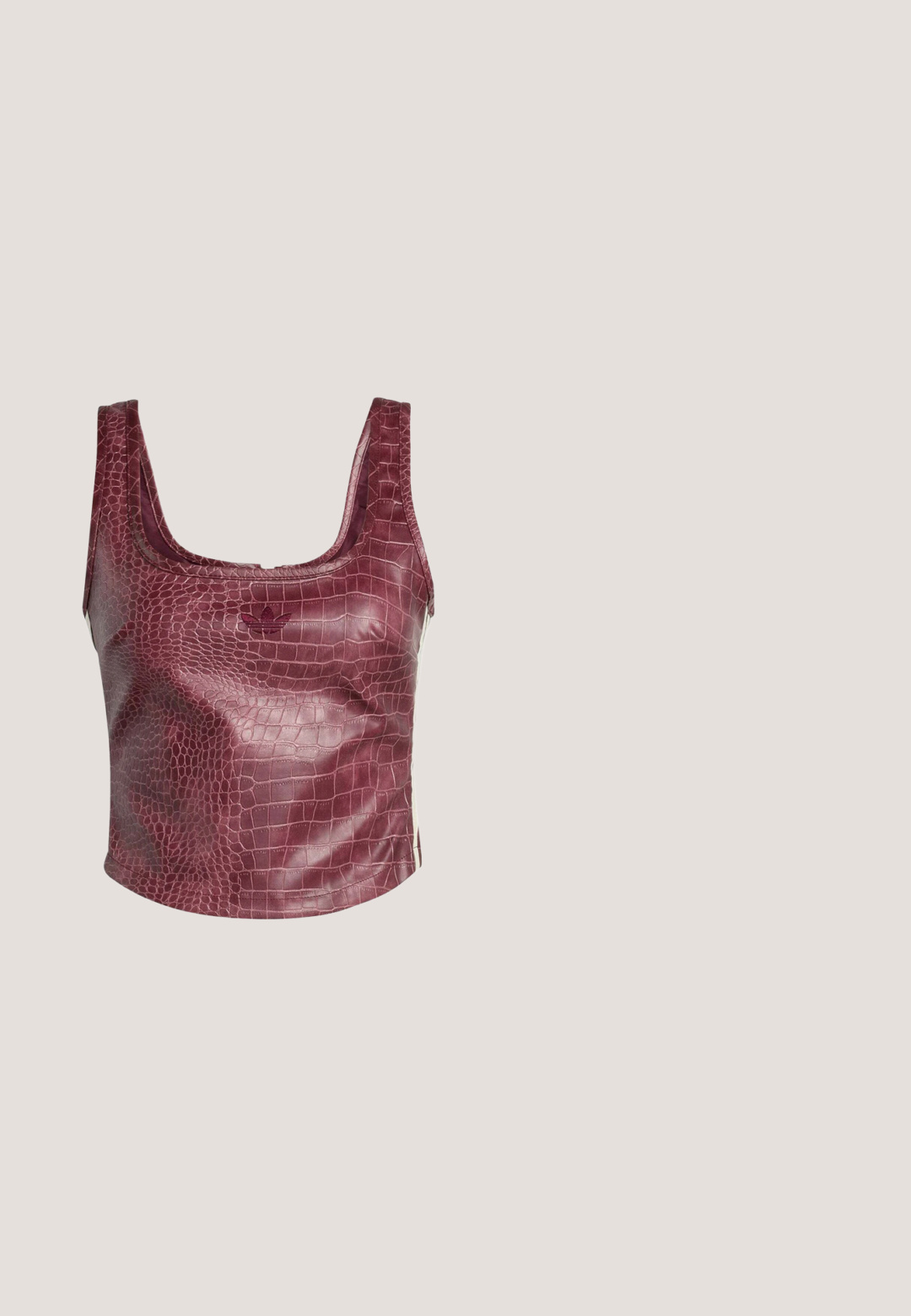 Hihaton lyhyt toppi, jossa burgundinpunainen keinonahkainen krokotiilinahkatekstuuri ja hillitty Adidas-trefoil-logo etukeskellä.; Burgundy tekonahka leggingsit, joissa on sileä pinta, korkea vyötärö ja tiukasti istuva muotoilu, joka ulottuu nilkkoihin ilman lisäkoristelua.; Ruskeat mokkasiilit, joissa on terävä kärki, hopeiset neliönmuotoiset niitit reunoilla ja säädettävä nilkkahihna soljella.; Kuusikulmaiset aurinkolasit, joissa on läpikuultavat vaaleanpunaiset linssit ja kultainen metallikehys. Sangoissa on teksturoitu vaaleanpunainen yksityiskohta, joka tarjoaa ainutlaatuisen muotoilun.; Vaaleanpunainen pompom-texuuri laukku, jossa on punottu kahva ja ohut hihna. Pyöreä muoto, pehmeä pinta, kompakti muotoilu.; Kultainen rannekoru, jossa on kirkasta, faacettista jalokivimateriaalia, joka on vuorotellen suorakaiteen ja timantin muotoisia edessä. Sileä pinta.