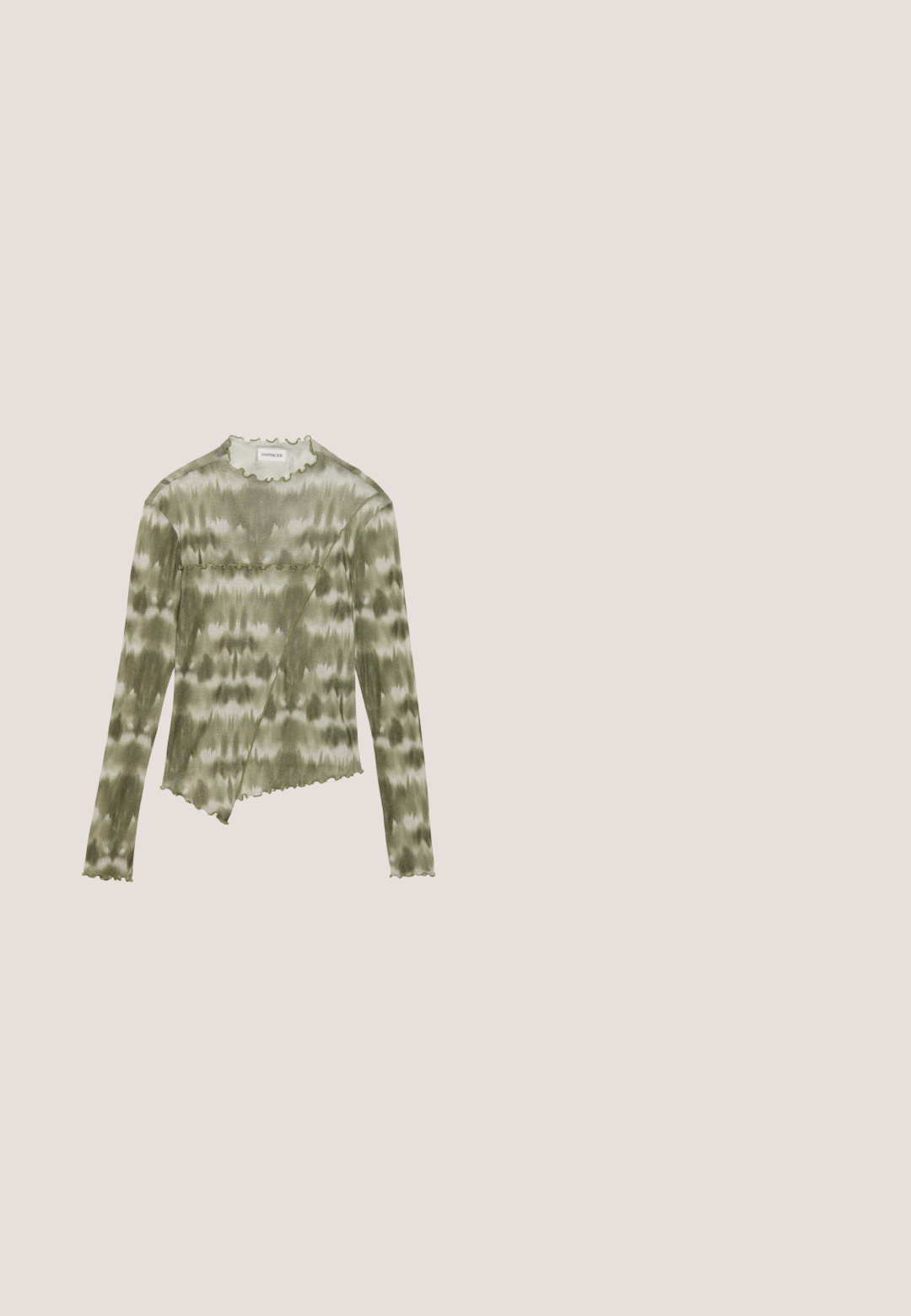 Top de manga larga, en verde de teñido anudado, con un escote y un dobladillo con forma de onda. Presenta una costura diagonal con acentos texturizados en una tela suave y ligera.; Pantalones cargo en verde oliva, hechos de tela ligera. Las características incluyen una cintura con cinturón, pliegues frontales y bolsillos laterales con cierres de solapa.; Sandalia de tiras marrón claro con una gran hebilla dorada sobre una alfombra azul texturizada, una silla acolchada gris parcialmente visible en el fondo.; Gafas de sol negras en forma de ojo de gato con lentes gris oscuro, marco de plástico elegante, esquinas puntiagudas y patillas rectas. Sin herrajes ni acentos visibles.; Bolso de hombro de cuero negro con una textura suave, forma curvada, correa ajustable y cierre con cremallera. Diseño minimalista sin adornos.; Pendientes de aro de plata con un acabado pulido, que presentan una forma circular y un cierre de gancho. Textura suave con detalles mínimos.