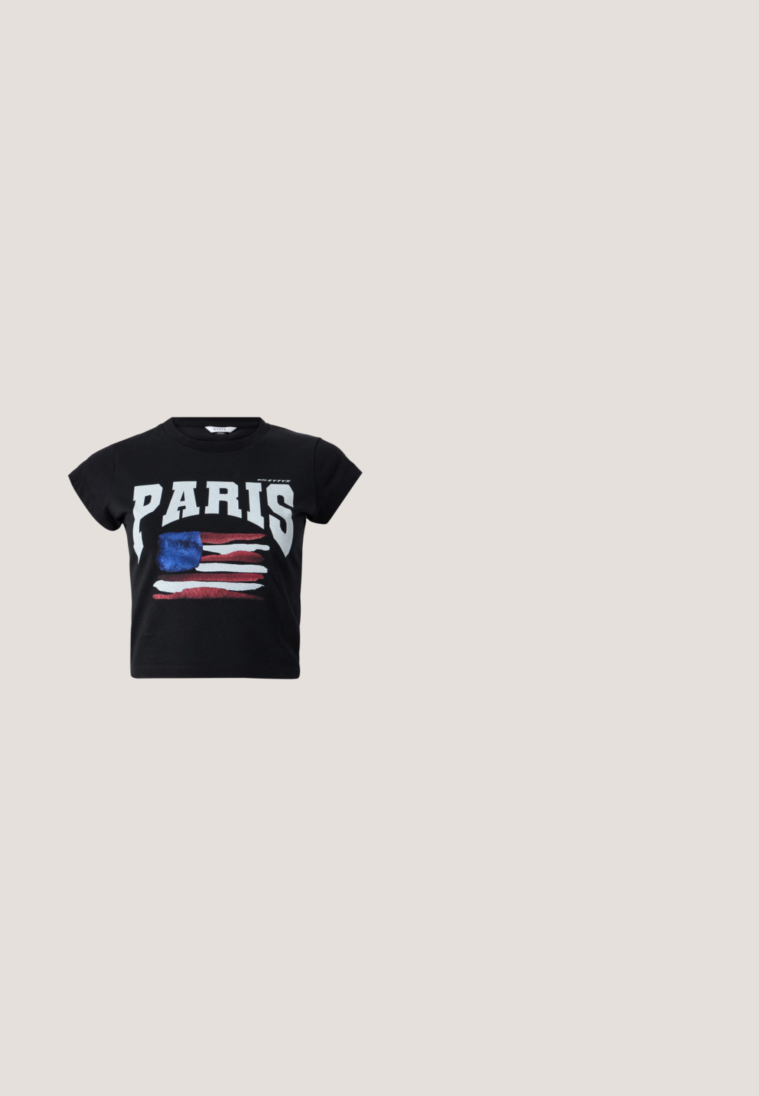Sort bomulds t-shirt med "PARIS" i fede hvide bogstaver og et slidt amerikansk flag grafik i rød, hvid og blå. Korte ærmer.; Vidde mørke denimbukser med asymmetrisk indpakningsdetalje foran og en figursyet talje, vist mod en hvid baggrund.; STAND STUDIO KELSEY - Mules med hæl - black; Sorte ovale solbriller med mørke linser og brede stænger med gyldne teksturerede paneler på hver side.; Sort vævet tote-taske med bred blæserform, frynset øverste kant, to håndtag og en dekorativ sløjfe på det ene håndtag.; Armbånd med guldfarvet tone med sorte emaljesegmenter og "RL" indgraveret på den centrale guldstang mod hvid baggrund.