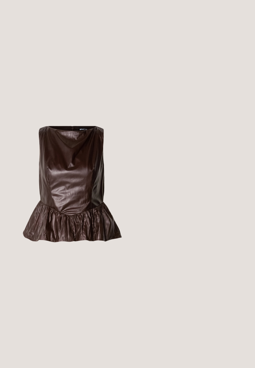Brun læder peplum top med en rund halsudskæring, tekstureret overflade og en flared flæse ved kanten. Rent, minimalistisk design.; Brun nederdel med nålestriber, tætsiddende design, glat tekstur og flared kant, ideel til et skræddersyet look.; Mørkebrune læder cowboystøvler til knæene med spidse tæer, dekorativ syning og skrå blokhæle, båret af en person.; Brune-farvede rektangulære briller med en glat overflade, der har slanke arme og gennemsigtige linser. Logoet er synligt på venstre temple.; Mørkebrunt patentlæder håndtaske med sølv kæderekke, dekorerede dobbelte spænder og lynlås lukning.; Sølvfarvede metaloorringe med glat, let buet overflade og låsemekanisme på en ensfarvet hvid baggrund.