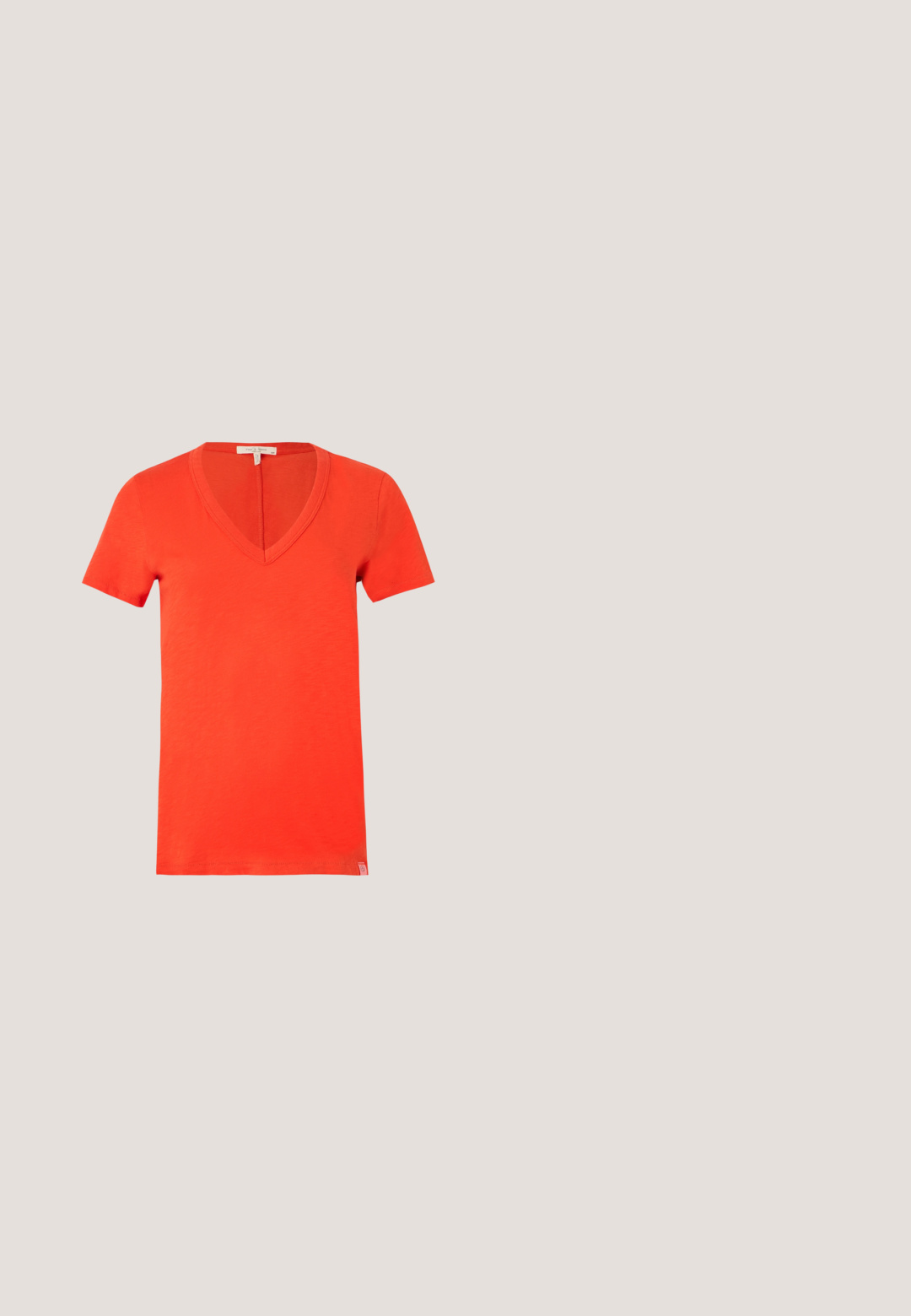 Lyse orange kortærmet bomuld t-shirt med dyb V-udskæring og et lille mærke i nederste kant på hvid baggrund.; Bukser i blød, lys rosa stof med lige snit, der har en frontlynlås, knaplukning og sidelommer. Glat tekstur med sømdetaljer.; Brun mule med åben tå, lav stablet hæl og bred rem med subtilt mønster og lille guldfarvet spænde.; Gennemsigtige gule solbriller med brune linser, der har mønstrede stænger og et slankt, vinklet rammedesign.; Sort Michael Kors skuldertaske med guldtone logo charm, justerbar rem og gentagende MK monogram mønster.; Øreringe i guldton med pil-design, der gennemborer et hjerte udsmykket med krystaller, med krystalaccents på pilens spids og hale.