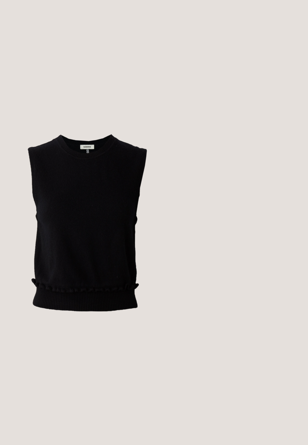 Pull noir sans manches en tricot doux. Doté d'un col rond et d'un ourlet inférieur froncé avec une bordure côtelée. Design simple et moderne.; Jupe en denim blanc dotée d'une fente à l'avant, d'un design à cinq poches, d'une fermeture à bouton et à zip en métal, ainsi que de détails de couture en bas.; Chaussure plate en cuir marron avec lanière arrière, bout pointu et logo entrelacé C doré sur un tapis beige près d'une table marron.; Lunettes de soleil noires en forme de chat avec des verres foncés. Présentent des accents dorés et verts sur les branches. Monture en plastique lisse et design élégant.; Petit sac bandoulière en cuir marron avec motif foncé, détail en chaîne dorée, fermeture à rabat et bandoulière réglable en cuir noir.; Ceinture en daim marron avec une boucle double ardillon dorée et une doublure intérieure contrastante couleur tan. Elle présente une texture lisse et plate ainsi que des extrémités arrondies.
