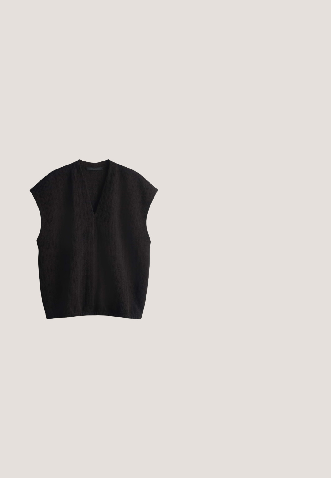Zwarte mouwloze top met een V-hals, van textuurstof en een losse pasvorm. Heeft een relaxed silhouet en een licht afgeronde zoom.; Lichtbeige wijde broek met voorzakken, een knoop- en trekkoord in de taille en omgeslagen zomen.; Zwarte slidesandaal met twee verstelbare bandjes en gouden gespen, kurken voetbed en zwarte zool.; Zwarte rechthoekige zonnebril met dikke monturen en bruin getinte glazen, plat op een witte ondergrond gelegd.; Beige en zwarte stoffen handtas met dubbele leren handvatten, verstelbare stoffen schouderband met gouden gesp en leren gespdetail aan de voorkant.; Gouden kettingarmband met een glad, soepel ontwerp, voorzien van een sluiting en een verstelbare ketting met een klein label.