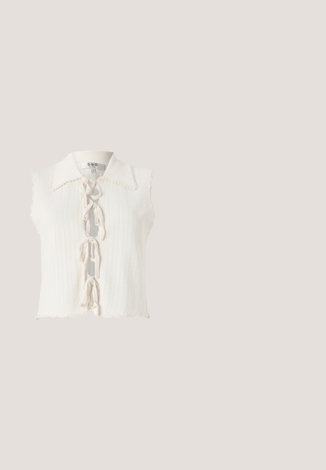 Hvid ærmeløs top med en bølget krave, struktureret strikket mønster, frontlukning med sløjfer og et cropped fald.; Sort, hvid og brun zigzag-mønstret strikkjole med klokkeærmer og rund halsudskæring, der har et tekstureret åbent vævdesign.; Platform-sandaler med beige faux suede-stropper, udsmykket med juvelbesatte accenter og en vævet jutebase. Tekstureret korkfodbed.; Brune skildpadde solbriller med gradientlinser, katteøjeform og guldmetal akcenter på stængerne og arme.; Sort lædertaske med AGL-logo i guld, justerbar rem og flaplukning på en ensfarvet lys baggrund.; Vanrycke LETTRINE S PENDENTIF OR ROSE - Vedhæng - rose gold-coloured