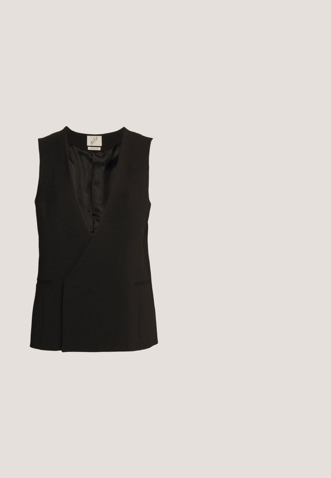 BITE Studios TUXE SLEEVELESS - Bodywarmer - black; STAUD NYLA - Top - black; Zwarte wijde pijpenbroek gemaakt van lichte stof, met een gladde textuur, een sluiting met knoop aan de voorkant en zijzakken.; Grijze leren sandaal met hak, voorzien van een geknoopte band bij de tenen en wikkellinten rond de enkel op een slanke sandaal met een middenhoge hak, tegen een witte achtergrond.; Zilveren metallic handtas met een glad, gebogen oppervlak, voorzien van een kettinghengsel en een veilige sluiting. Compacte vorm en reflecterende afwerking.; Zilveren oorringen met een gebogen, glanzende afwerking en een naadloos ontwerp. Voorzien van een scharnier slot voor veilige draagbaarheid.