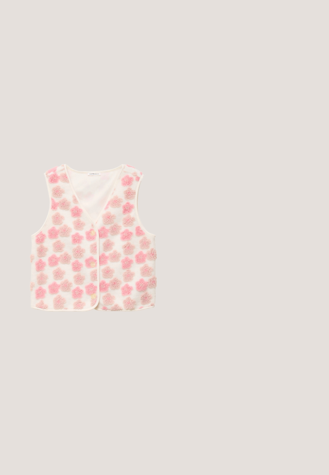 Witte mouwloze blouse met zachte roze en beige getextureerde bloemenpatronen en drie knopen aan de voorkant.; Perzikkleurig katoenen T-shirt met een grafisch ontwerp dat een getekende figuur, bloemen en abstracte vormen in rood, groen en blauw toont.; Katoenen pyjamabroek met een licht beige achtergrond en een rood toilepatroon dat pastorale taferelen uitbeeldt. Elastische tailleband en contrasterende zoom.; Roze sneaker met bloemmotief op het bovenwerk en een dikke zool, voorzien van roze veters en een klein metalen logolabel.; Lichtroze vierkante zonnebril met donkerroze lenzen. Matte afwerking, dunne veren, en de tekst "EYES NEVER LIE" in reliëf aan de zijkant.; Roze draagtas met lange handgrepen, versierd met kleine rode stippen, roze bloemen en teddyberen die blauwe jassen en rode hoeden dragen.