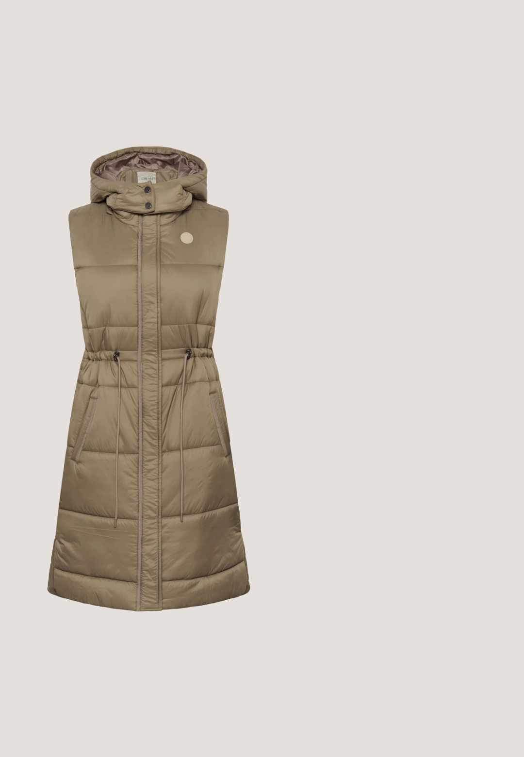Polstret ærmeløs vest i khaki med snoretræk i taljen, lynlås- og trykknaplukninger, to sidelommer og hætte. Glat, skinnende stof.; Løs pasform, kortærmet sweater i olivengrøn med rund halsudskæring og blødt, tekstureret strikket stof.; Sorte bukser med en blanding af denim og læderpaneler. Designet er bredt i benene med teksturvariationer, hvilket skaber en tydelig visuel kontrast.; Grønne lædertræsko med et slankt design, der har en sort platformssål og kontrasterende syninger langs den øverste kant.; Mørk olivengrøn læder skuldertaske med gulddetaljer, topstrop, justerbar rem og forflap med spænde.; Guld hoops øreringe med en poleret finish, der har en rund form og en sikker låsemekanisme. Den glatte, reflekterende overflade forbedrer designet.
