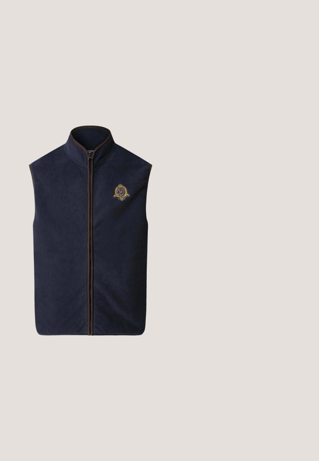 Hackett London HERITAGE CREST  - Bodywarmer - midnight blue; Lichtblauwe polo met korte mouwen van zachte katoen. Beschikt over een drieknops sluiting, kraag en geborduurd logo op de borst.; Marineblauwe broek met rechte pijpen, een tailleband, ceintuurlussen en een striksluiting aan de voorkant.; Marineblauwe sneaker met suède en leren panelen, bruine hielaccent, witte tussenzool, zwarte zool en een "H"-logo aan de zijkant.; Zwarte rechthoekige Tommy Hilfiger zonnebril met donkere lenzen en subtiele zilveren accenten op de pootjes van het montuur.; Donkerblauwe leren crossbodytas met voorflap, ritssluiting en verstelbare schouderriem.
