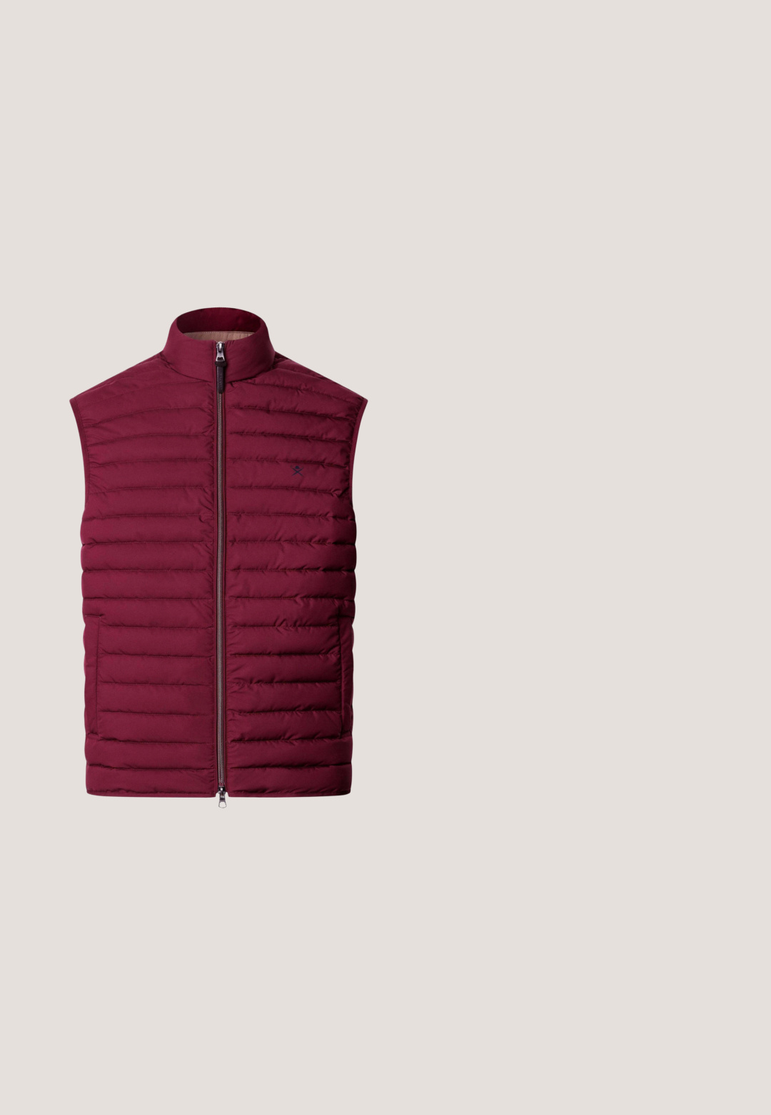 Veste sans manches matelassée couleur marron foncé avec col montant et fermeture éclair à l'avant.; Pull à col roulé bordeaux en tissu doux, avec des manches longues, un col et des poignets côtelés, et une texture lisse sur l'ensemble.; Chemise habillée homme à manches longues de couleur bordeaux foncé avec col classique et boutons noirs, posée à plat sur fond blanc.; Pantalon de survêtement bordeaux avec taille à cordon, poignets côtelés, deux poches latérales et une petite étiquette logo noire sur la cuisse gauche.; Baskets basses bordeaux avec bande latérale noire, talon noir, fermeture à lacets et semelle en caoutchouc marron sur fond neutre.; Trousse de toilette rectangulaire en cuir bordeaux avec une poignée latérale et un logo de marque noir discret sur le devant.
