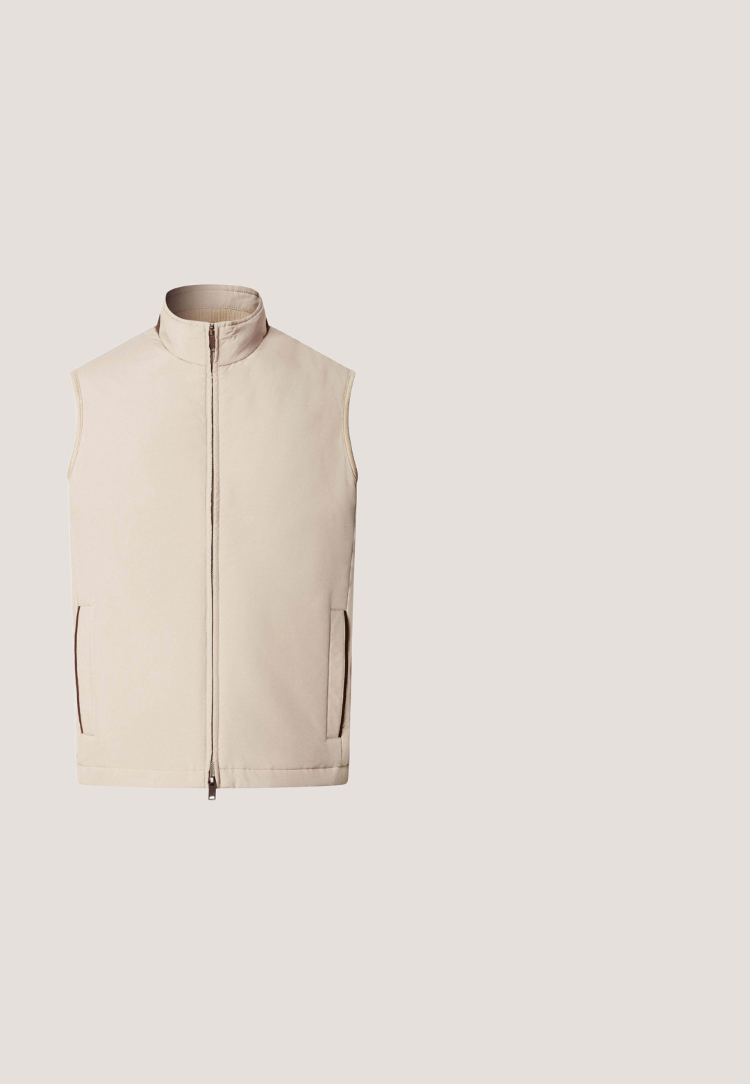 Chaleco sin mangas beige con cuello alto, cremallera frontal y dos bolsillos laterales.; Polo de manga larga beige con cuello, tapeta con un solo botón y etiqueta de la marca HUGO en rojo dentro del cuello.; Pantalones beige a medida con una textura suave, que cuentan con cierre de botón, pliegues frontales y piernas cónicas.; Mocasín deslizante de gamuza azul con suela de goma blanca y detalle de costuras sutiles, vista lateral.; Bolsa de lona de cuero marrón con dos asas y cierre superior con cremallera, mostrada sobre un fondo blanco liso.; Cinturón de cuero topo con hebilla rectangular plateada y bordes cosidos, enrollado cuidadosamente sobre un fondo blanco.