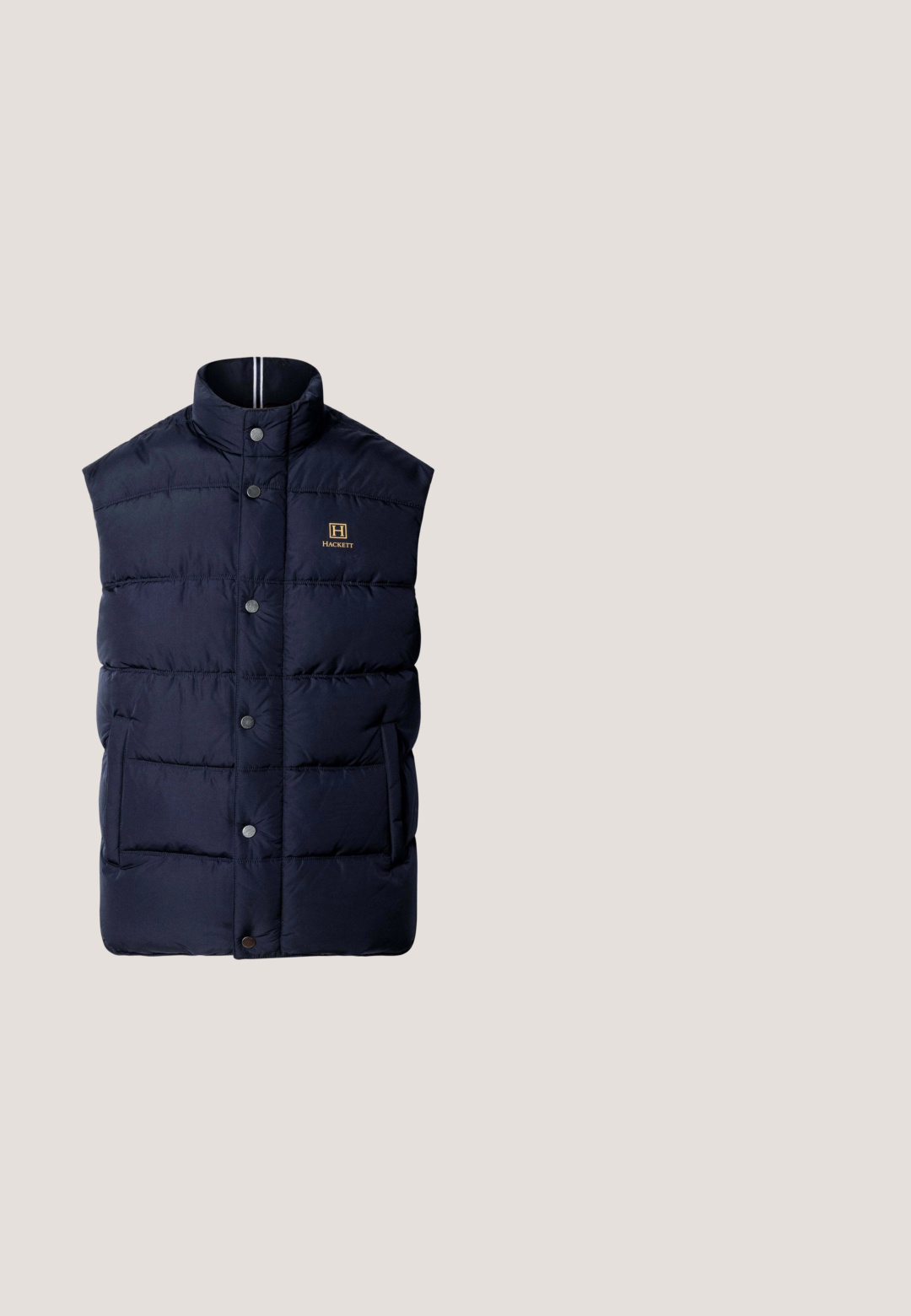 Chaleco acolchado sin mangas en azul marino con cuello de pie, botones a presión delanteros, bolsillos laterales y pequeño logo de Hackett en el pecho.; Jersey marrón de punto con mangas largas, cuello con media cremallera acanalado, puños y dobladillo, presentado sobre un fondo gris claro.; Camiseta de manga larga en algodón burdeos oscuro, diseño de cuello redondo, textura suave y sin patrones ni acentos visibles.; Façonnable REGULAR FIT GARMENT DYED CORDUROY - Pantalones - naval blue; Zapatilla de corte bajo de ante marrón y negro con suela beige y cuello acolchado, vista desde el lado exterior.; Neceser de piel marrón con forma rectangular, cierre de cremallera en la parte superior y asa lateral. Logotipo de la marca en relieve en la parte frontal.