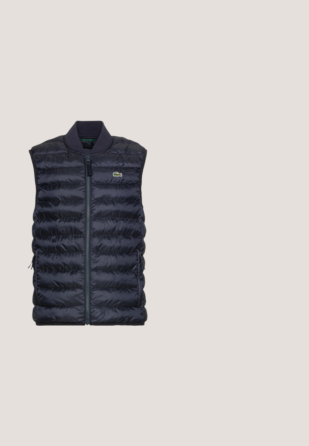 Tumed puffer vest horisontaalselt quiltitud tekstuuriga, täielik eesmine tõmblukk ja ribaga krae. Omab küljetaskuid ja väikest rohelist logo.; Heleroheline pikkade varrukatega pullover kvartlizapiga, kõrge krae, rinnal reljeefne brändiplaat ja vasakul mansetil väike logo.; Hele sinine puuvillane t-särk ümara kaelusega, vasakul rinnal tikitud väike kollane linnu logo. Lühikesed varrukad, ühtlane värv.; Beežid treeningpüksid elastse vöökohaga ja ääristega, millel on väike rohelise krokodilli tikand paremal reiel.; Valged studenti tossud beige suede aktsentide ja tumesiniste triipudega. Omavad tekstureeritud kummitalda ja väikest roheline krokodilli logo külje peal.; Tumedat sinise tekstuuriga käsipadi, millel on tõmblukuga sulgemine, kaks tõmbluku tõmburit, reguleeritav rihm ja lame disain, sobib igapäevaseks kasutamiseks.