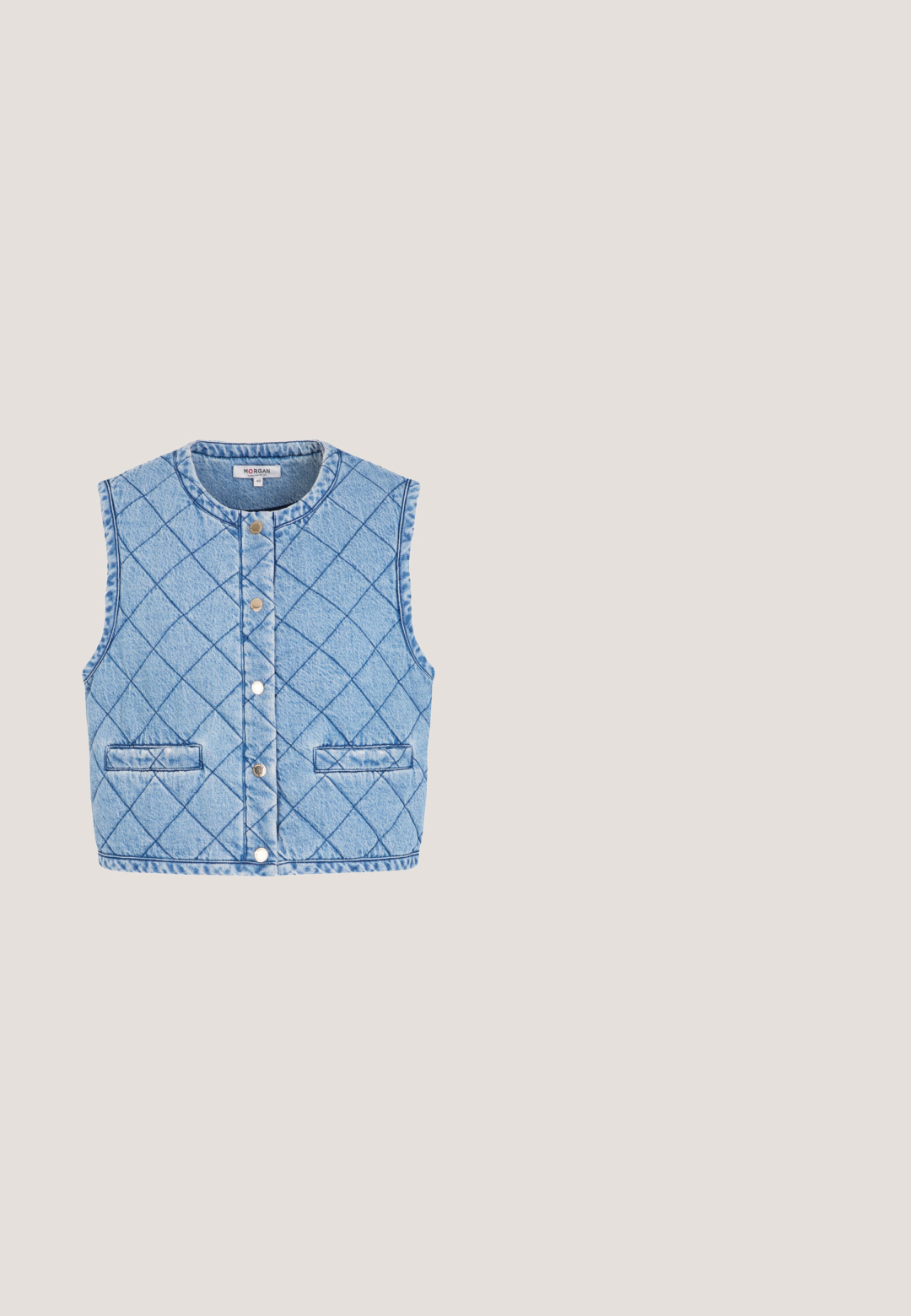 Lyseblå quiltet denimvest uden ærmer med trykknapper foran og to vandrette stiklommer.; Lys blå strikket sweater med lange ærmer, kort design, med spredte røde hjerte-motiver over det hele, samt ribbede manchetter og kant.; Lilla tanktop med tynde stropper, med ordet "Juicy" i metallisk stil på brystet, lavet af blødt, glat stof.; Lyseblå mesh- og ruskindssneaker med hjerteformet charm og pompomer på toppen, gummisål og "Steve Madden" logo på siden.; Lyseblå trapezformet håndtaske med blomsterprintet tørklæde viklet rundt om håndtagene og en lille guldbie dekoration centreret nær toppen.; Guld butterfly drop-øreringe med klare krystaller og hvide perleperler arrangeret langs en fin kæde.