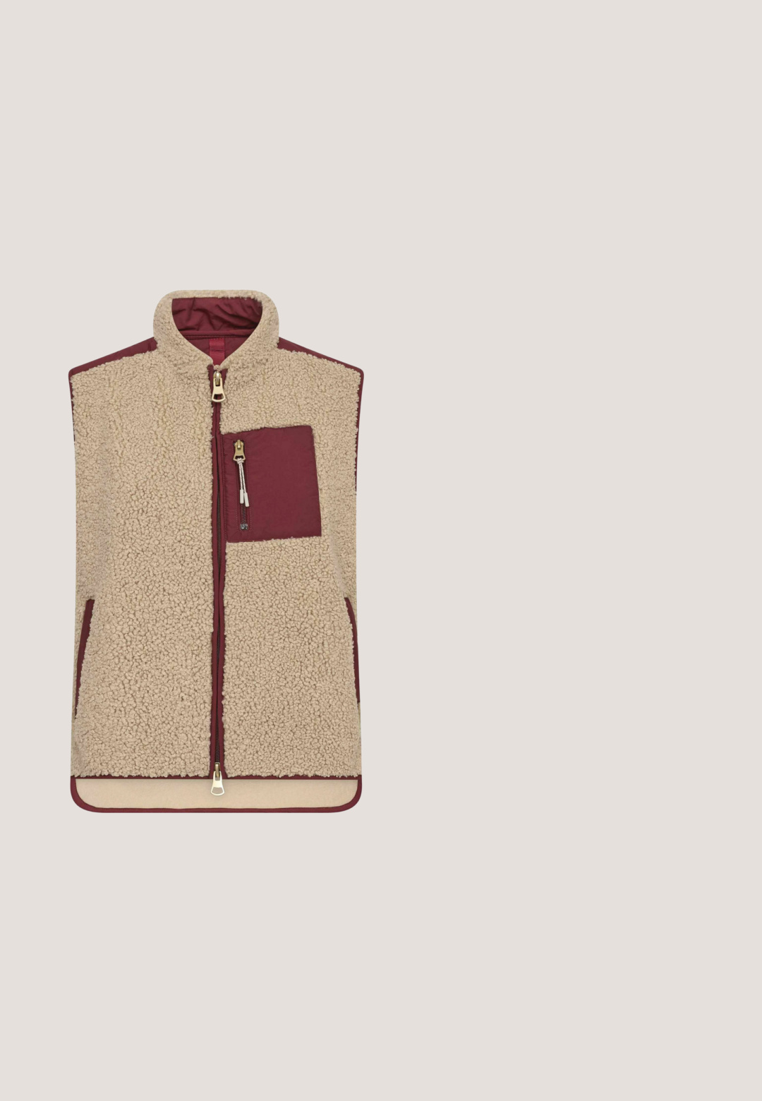 Ærmeløs fleecevest i beige med bordeaux kant, med lynlås foran og brystlomme med lynlås.; Langærmet, mørkerød pullover med spids krave og halv længde foran lynlås.; Maronfarvede ribbede leggings med en bred talje, der har struktureret stof og et lille brandlogo på hoften for ekstra detalje.; Mørkerød sneaker med en blanding af glat ruskind og strukturerede materialer, med en hvid mellemsål og ydersål i klistret gummi. Brandlogo vist på siden.; Brune runde solbriller med lyserøde gradientlinser og en blank finish på en hvid baggrund.; Mandarina Duck Skuldertasker - pecan nut