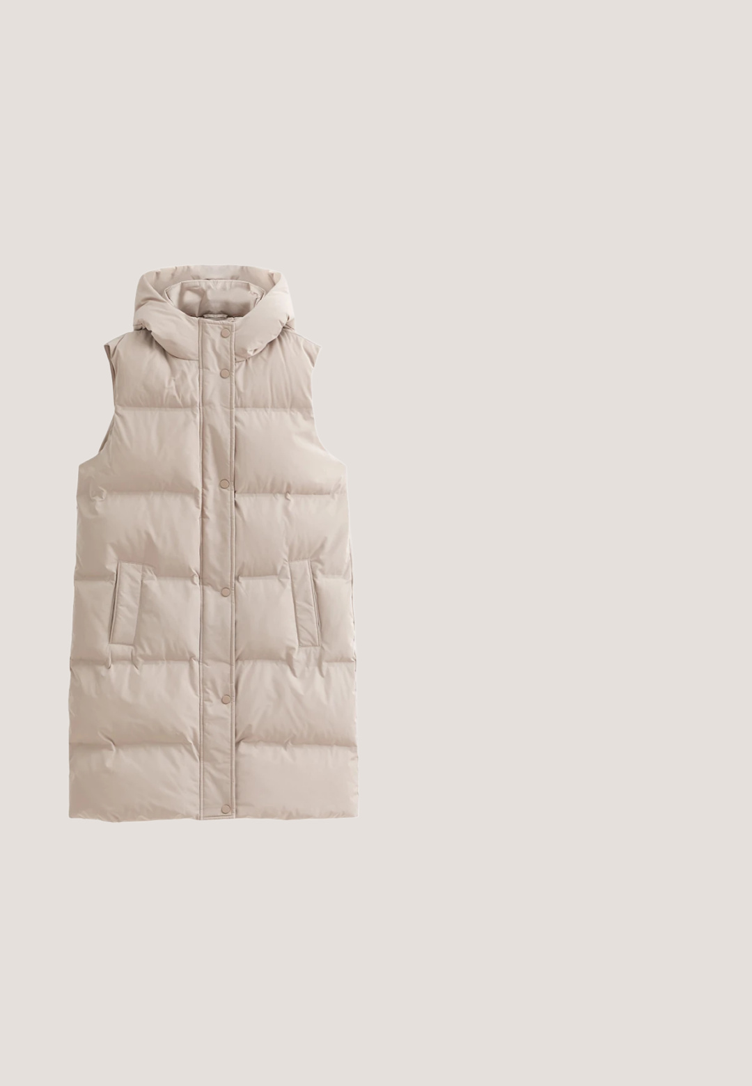 Chaleco acolchado sin mangas en beige claro, con capucha, botones a presión en el frente y dos bolsillos laterales. Textura de tela suave y acolchada.; Sudadera gris claro de manga larga con cuello redondo, hombros caídos y puños elásticos, estilo sencillo y casual.; Sudadera de cuello alto en color beige, de manga larga, fabricada en una tela suave, con un corte holgado, una sutil textura y sin patrones ni acentos visibles.; Pantalones jogger color crema hechos de tela suave, con cintura elástica, cordón ajustable y puños cónicos. Incluyen bolsillos laterales.; Zapatilla deportiva beige claro de punto, tipo slip-on, con patrones de ventilación texturizados y suela acolchada blanca, diseñada para comodidad casual.; Bolso tote beige con asas y laterales de tela acanalada, bolsillo frontal liso y logo "KAPTEN & SON" centrado en el bolsillo frontal.