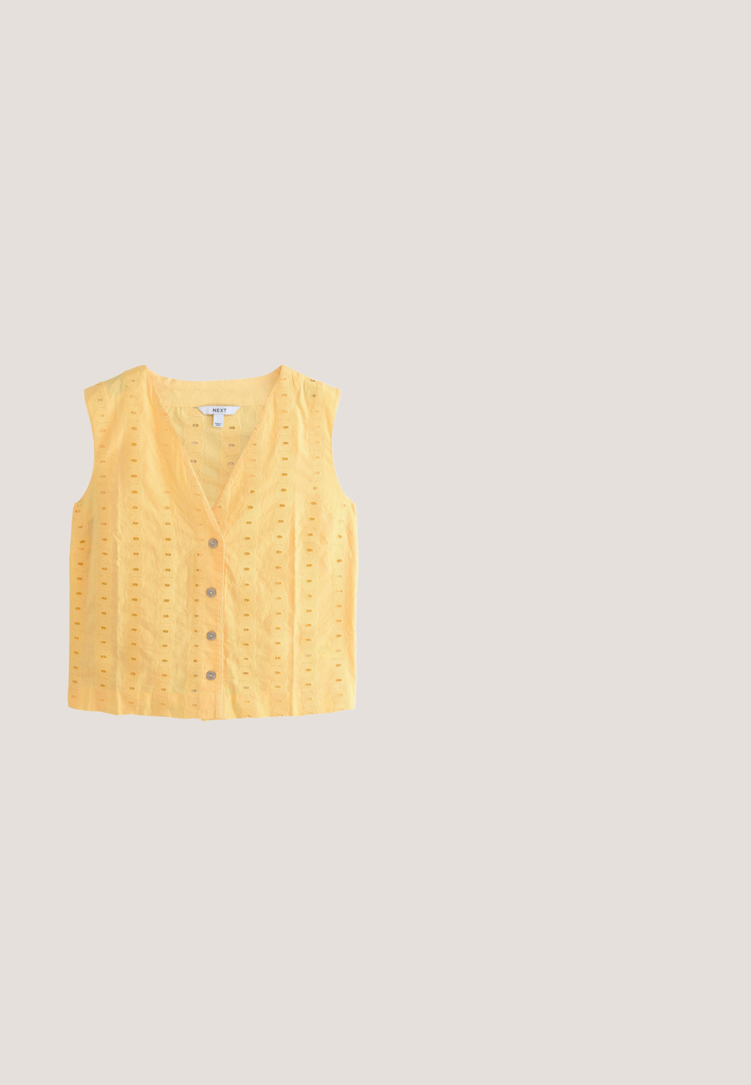 Bomuldsstof i blød gul med broderet bølgekantmønster. Har cirkulære knapper i perlemor langs fronten.; Hæklet gul og cremefarvet stribet tanktop med bindebånd på stropperne og et farverigt blomstermotiv med en skildpadde i midten foran.; Cremefarvede bukser med bred benvidde og høj talje, fem lommer, metalknap og stofsløjfer bundet langs begge bukseben.; Gul vævet flad sandal med to krydsede stropper, en knyttet detalje fortil og en lav, brun sål.; Lyseblå mulepose med cremefarvede rebhåndtag, broderet med teksten "Greetings from California", palmer og et strandpostkortdesign.; Justerbar sort snorearmbånd med skiftende hvide og gule perler, en guldfarvet blomst charm og et lille rektangulært guldfarvet mærke.