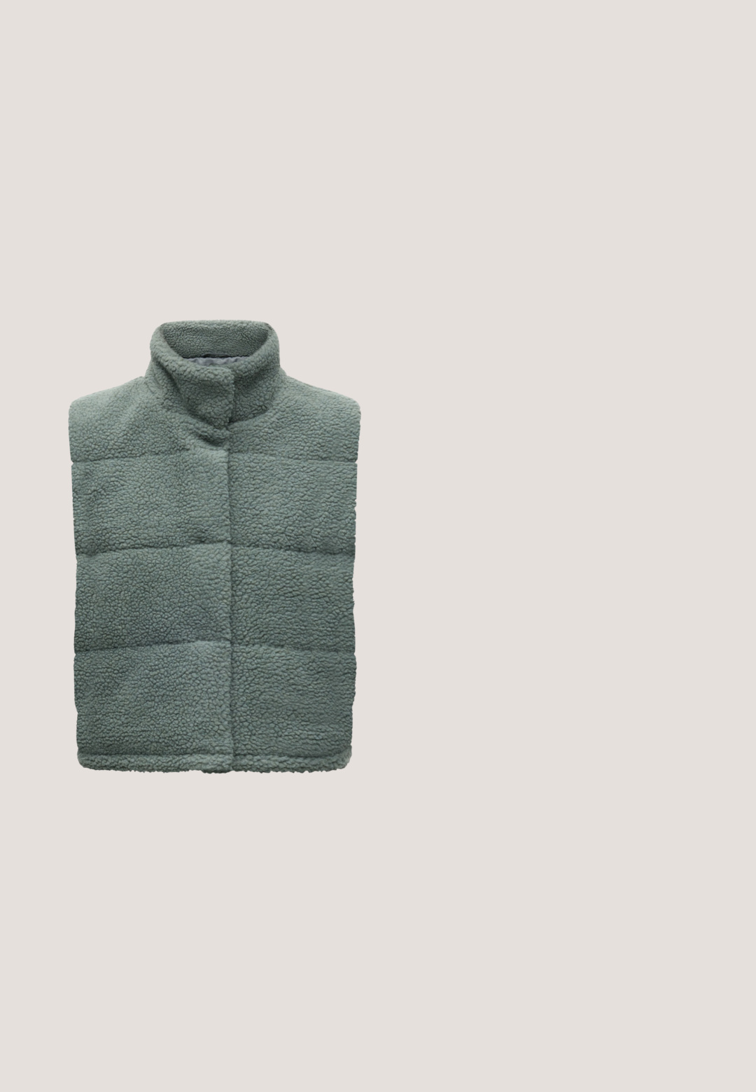 Veste sans manches en polaire sherpa vert-gris avec coutures matelassées et col haut, présentée à plat sur un fond clair.; Pull en maille verte avec un col montant, de longues manches bouffantes et des poignets côtelés. Présente un motif texturé à rayures horizontales.; Pantalons cargo en velours côtelé vert foncé, à coupe ample, dotés de deux poches latérales et d'une taille élastique confortable. Tissu texturé.; Baskets en daim vert avec des accents blancs et un logo en étoile, associées à un pantalon large à carreaux bleus, posées sur un sol jaune.; Sac fourre-tout vert clair matelassé avec anses rembourrées et petite étiquette de logo blanche centrée près du haut sur fond uni.; Boucles d'oreilles vertes translucides en forme de hoop avec un design ouvert et courbé, et une finition brillante. Elles disposent d'un fermoir à clou pour un port sécurisé.