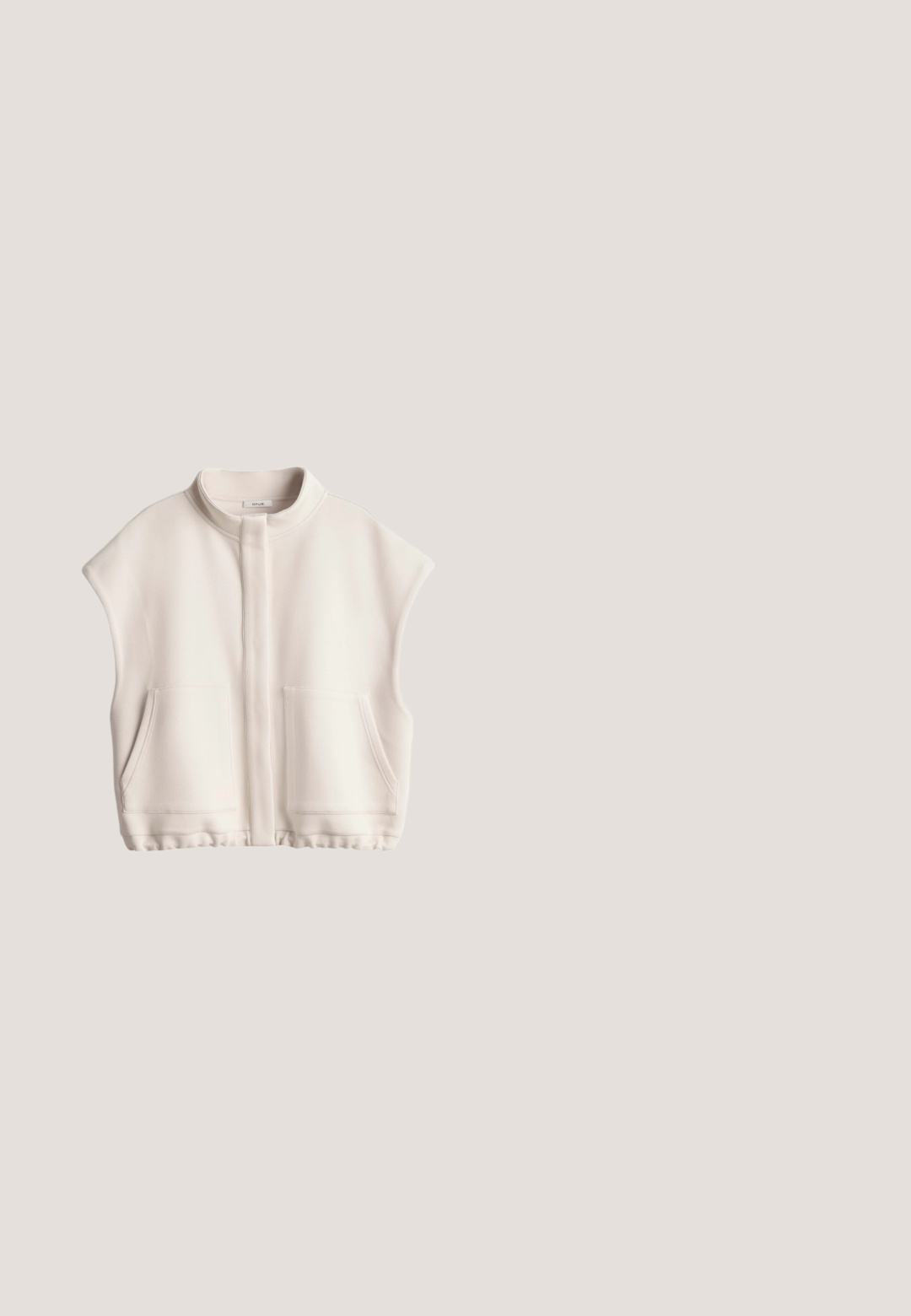 Cremefarbene ärmellose Weste mit Reißverschluss, Stehkragen und zwei Fronttaschen, flach auf weißem Hintergrund präsentiert.; Beiges, oversized Sweatshirt mit kurzen Ärmeln, abgefallenen Schultern und rundem Ausschnitt, auf weißem Hintergrund dargestellt.; Beige Shorts mit elastischem Bund und Kordelzug, aus strukturiertem Stoff mit zwei Fronttaschen. Mittlere Oberschenkel-Länge.; Beiger gestrickter Sneaker mit vorderer Schnürung, Ausschnitt-Details an den Seiten, strukturierter Sohle und Zuglasche an der Ferse, im Seitenprofil gezeigt.; Transparente beige Katzenaugen-Sonnenbrille mit braunen Gläsern und dünnen goldenen Bügeln, die auf einer weißen Oberfläche liegt.; Cremefarbene, gesteppte Tragetasche mit kurzen Griffen und Reißverschluss, vor weißem Hintergrund gezeigt.