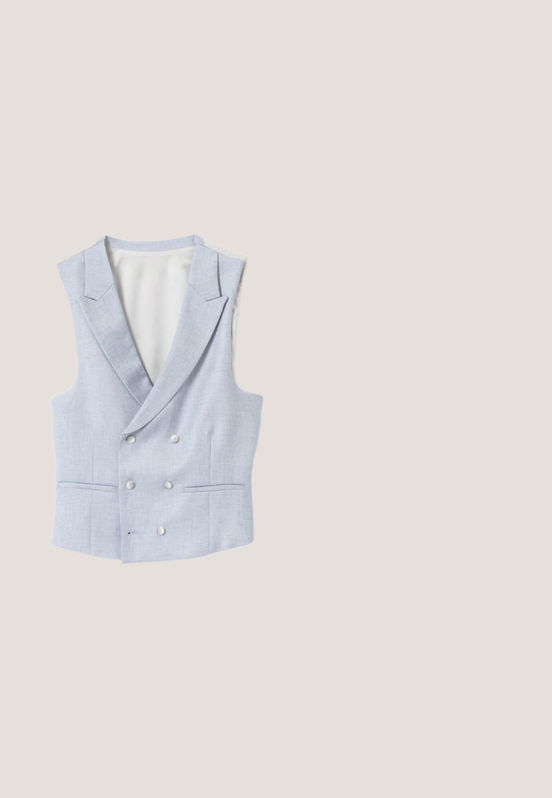Chaleco cruzado gris claro con solapas con muescas, seis botones y dos bolsillos delanteros de ojal, mostrado plano sobre un fondo blanco.; Camisa azul claro con botones, rayas verticales blancas delgadas, mangas largas y cuello clásico, mostrada sobre un fondo blanco.; Pantalones de traje de hombre en azul marino, ajustados, con pasadores para cinturón y cierre de cremallera en la parte delantera, exhibidos sobre un fondo blanco.; Mocasín azul de cuero para hombre con patrones florales grabados y detalle de hebilla metálica dorada en la parte superior, tacón plano y marca estampada en el costado.; Corbata gris claro con un diseño floral en forma de escritura cerca del extremo puntiagudo sobre un fondo blanco liso.; Cinturón de cuero azul marino enrollado con una hebilla rectangular mate de plata que presenta un diseño único de recorte geométrico.