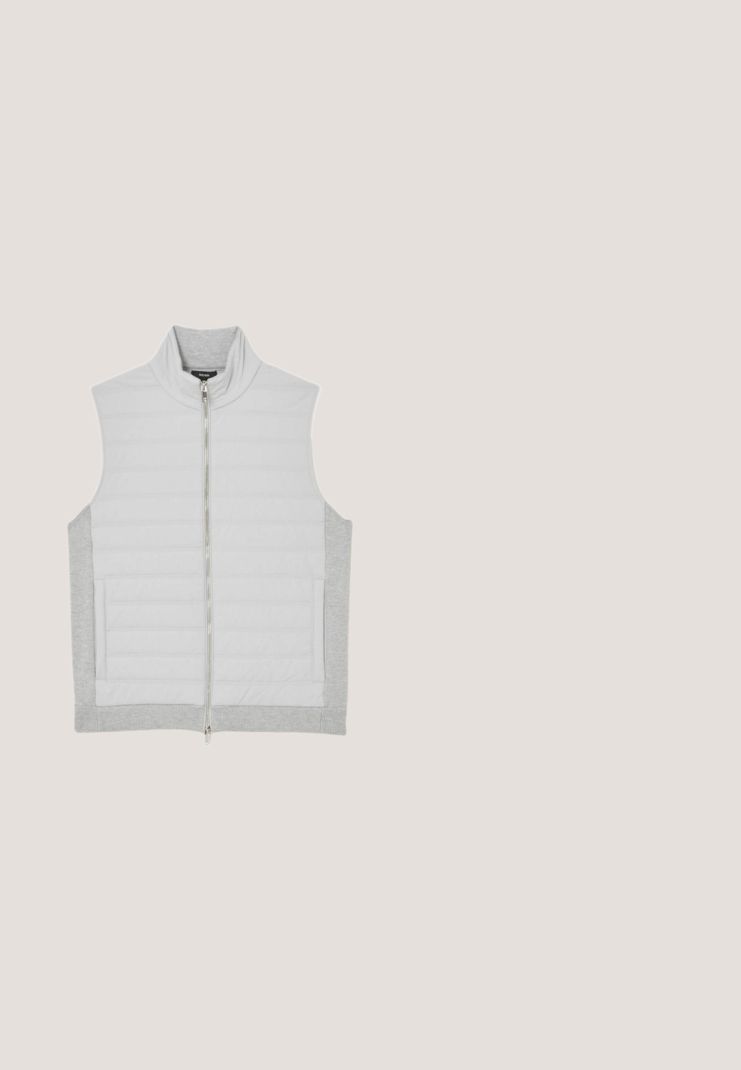 Chaleco sin mangas de un gris claro con un alto cuello, frente acolchado, espalda lisa y cierre de cremallera. Presenta detalles acanalados en el dobladillo y en los bolsillos.; Sudadera gris oscuro hecha de tela suave, con rayas horizontales blancas, un bolsillo tipo canguro y capucha ajustable con cordón.; Camiseta gris claro de manga larga con cuello redondo y costuras raglán, colocada plana sobre fondo blanco.; Pantalones jogger gris claro con cintura elástica, cordón, bolsillos laterales, tobillos con puños y un pequeño parche cuadrado con logo en el muslo.; Zapatillas de deporte bajas en gris y blanco con acentos en negro, paneles texturizados y la marca "Armani Exchange" en el lateral.; Bolso cruzado compacto en gris oscuro con un bolsillo frontal con cremallera, correa ajustable negra y el logo "JOOP!" en la parte frontal.