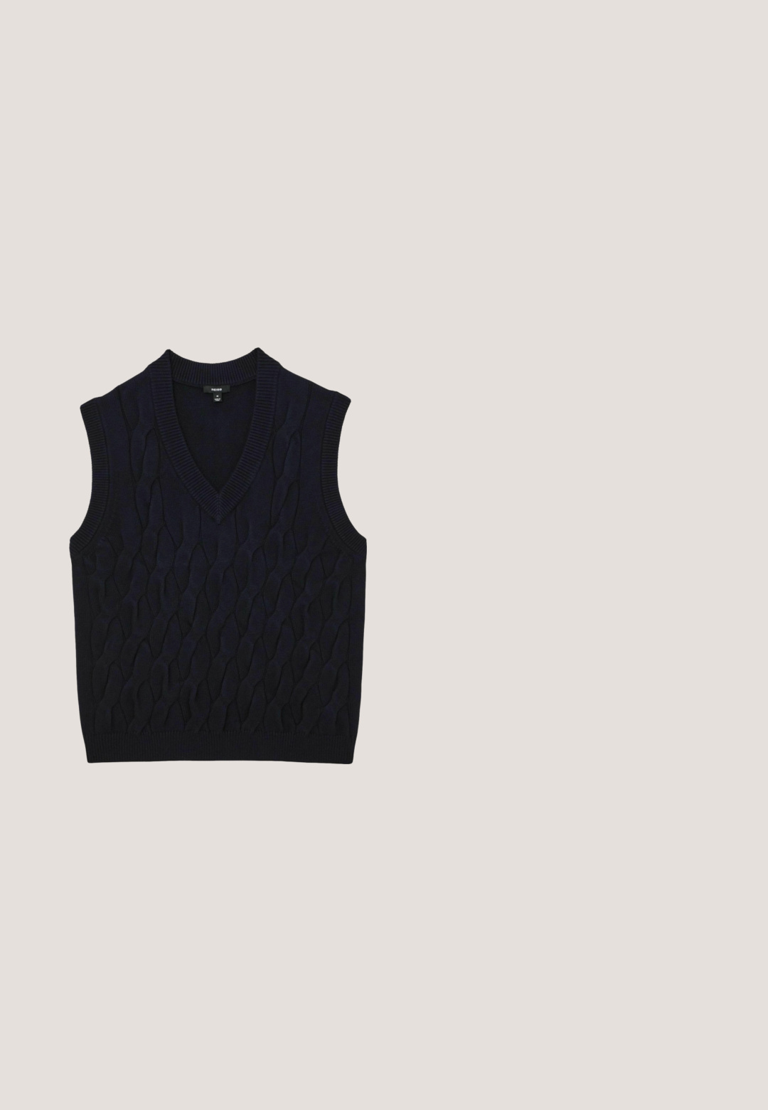 Navyblauwe mouwloze gebreide sweatervest met V-hals en kabelpatroon, geribde randen bij de halslijn, armsgaten en zoom.; Donkerblauwe herenblazer met dubbele knoopsluiting, ingesneden revers en drie voorzakken, afgebeeld tegen een witte achtergrond.; Witte blouse met lange mouwen, knopen en kraag, met klein geborduurd logo op de linkerborst, plat gelegd op een effen achtergrond.; Donkerbruine broek met rechte pijpen, voorzakken, riemlussen, knoop, ritssluiting en een zichtbaar GANT-merklabel aan de binnenkant van de tailleband.; Donkerbruine leren herensloffen met tassels, lage hak en subtiele stiksels langs de zijkanten en het teengebied.; Bruine leren riem met een gladde textuur, zilveren metalen gesp en een lusje. Heeft een solide ontwerp zonder patronen of accenten.