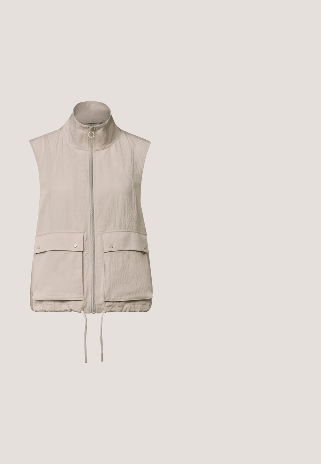 Ærmeløs beige vest med lynlås og høj krave, to forlommer med klap og trykknapper, samt justerbare snore i kanten.; Lysebrunt langærmet sweater lavet af blødt stof, med en rund halsudskæring og ribbet tekstur. Enkel, udekoreret design.; Beige top med høj hals, med en snor og trekvartærmer. Tekstureret stof med subtile vandrette striber.; Beige joggerbukser med elastisk taljebånd og snøre. Har to sidelommer med lynlås og en tilspidset benform. Blød tekstur.; Beige træningssko med en tekstureret strikoverdel, rund tå og snørebåndsdesign. Har en let hvid sål med en sølvdetalje.; Beige buddeltaske med brune læderdetaljer; har en frontlomme med lynlås, justerbar strop og sikker spændelukning.