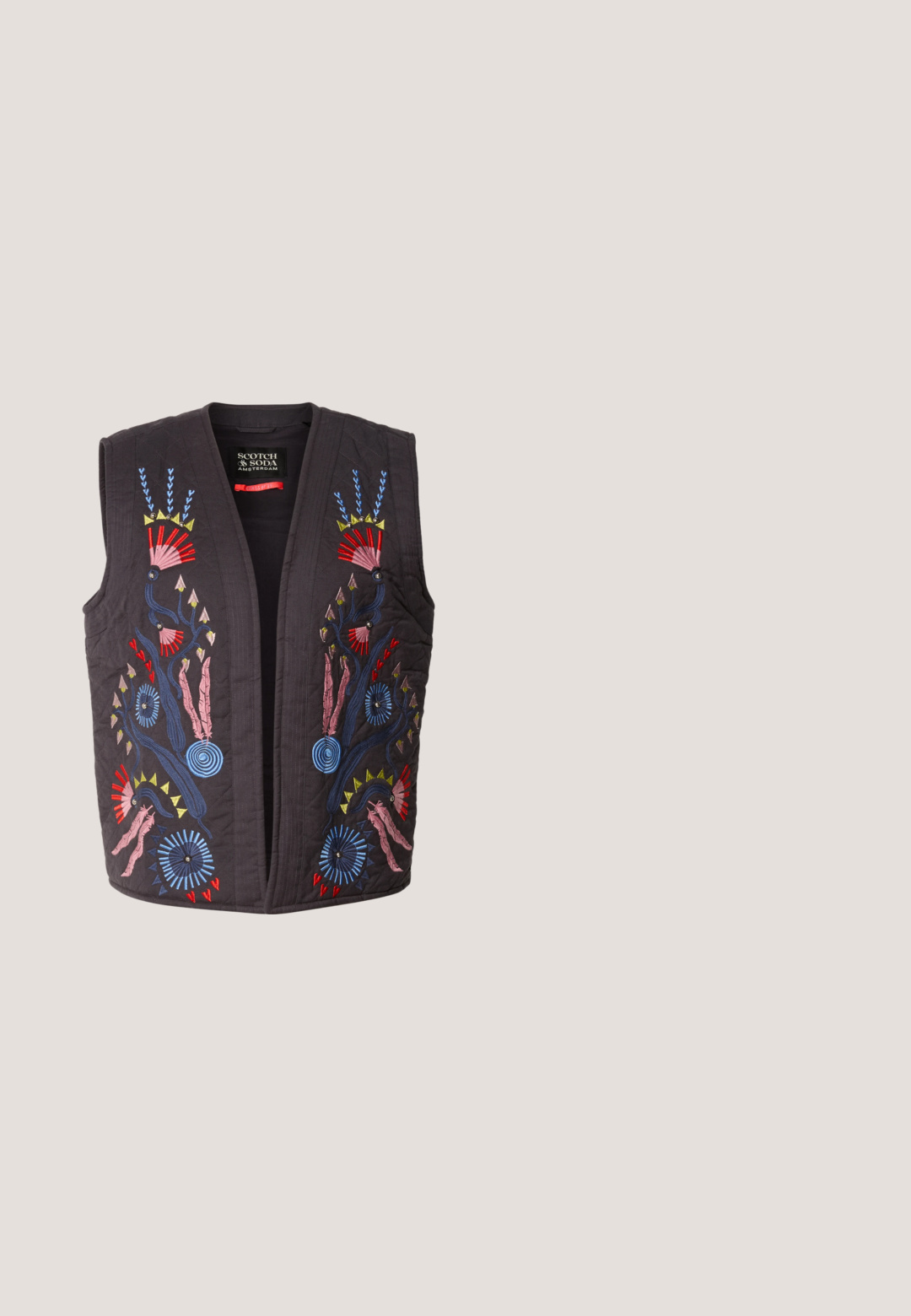 Gilet matelassé noir ornés de motifs floraux brodés colorés en rouge, bleu, rose et jaune. Aucune boutonnière ni fermeture visible.; Haut à rayures bleu marine et blanc à manches longues avec un décolleté large et un tissu doux et extensible. Présente des rayures horizontales uniformes sur l'ensemble.; Jean large en denim bleu foncé. Doté d'une taille haute, d'une fermeture à bouton et d'un design classique à cinq poches avec une légère décoloration.; Baskets en daim beige avec un design texturé, semelle en caoutchouc plate et couture latérale distincte. Bout arrondi et col rembourré.; Sac hobo en suède beige doux avec une forme décontractée, une large bandoulière et un détail de couture à la main sur le devant.; Boucle d'oreille en argent avec une finition polie, présentant de petits détails en or et de forme ronde, portée sur le lobe.
