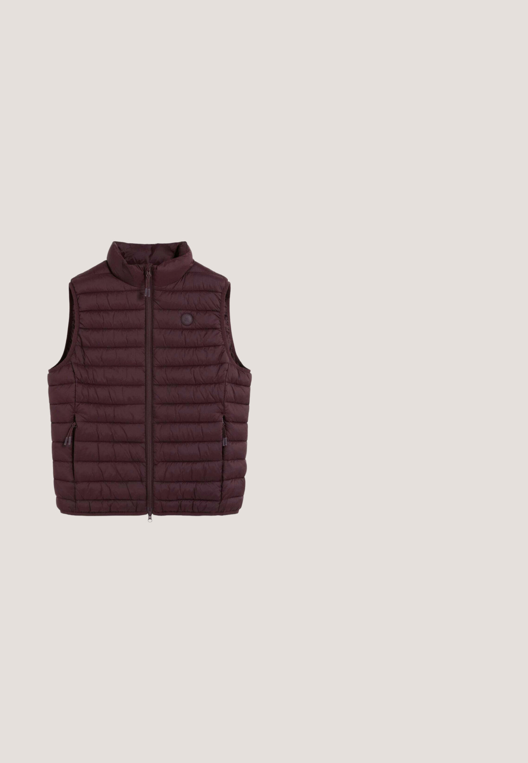 Chaleco sin mangas acolchado de color marrón oscuro con cuello alto y cremallera frontal, con dos bolsillos laterales con cremallera y un pequeño logo circular en el pecho.; Suéter de punto azul marino con un alto cuello acanalado, media cremallera y puños acanalados. El interior del cuello presenta un patrón a rayas.; Camisa henley de manga larga en color marino, hecha de algodón suave, con una tapeta de tres botones, dobladillo redondeado y pequeño logotipo en el pecho.; Pantalones de pana azul marino con corte recto, que cuentan con un cierre frontal de botón, trabillas para cinturón y bolsillos clásicos. Tejido texturizado.; Zapatillas de deporte de ante marrón con parte superior texturizada, cordones planos, detalle del logo en dorado y suela de goma. Forro interior blanco y acento en el talón de color azul oscuro.; Bolso bandolera de tela azul oscuro con dos bolsillos frontales con cremallera, correa de hombro ajustable marrón y dos asas de cuero.
