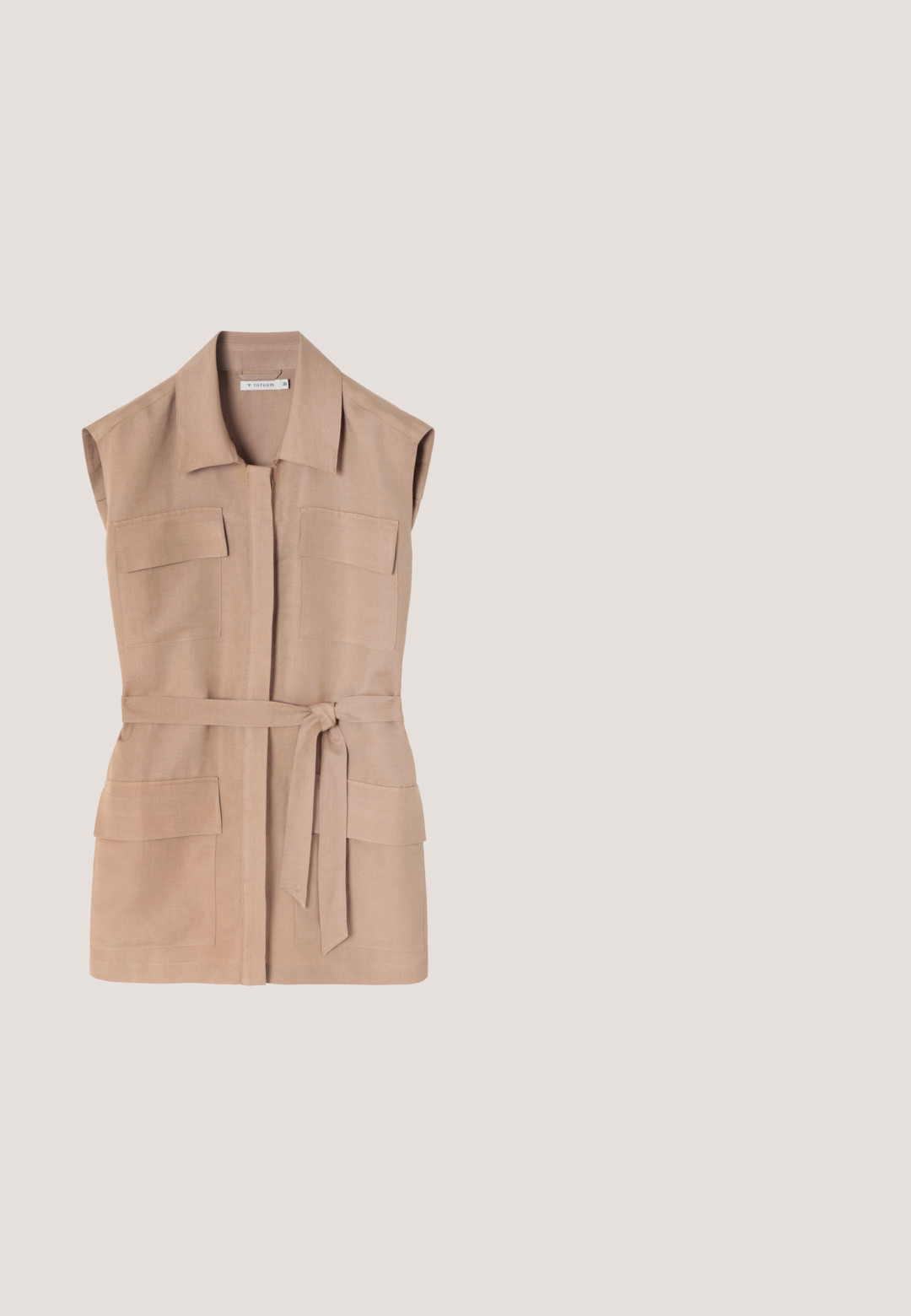 Veste sans manches beige en lin, dotée de deux poches poitrine, d'une taille ceinturée et d'une coupe droite. Design minimaliste sans fermetures.; Blouse crème à manches longues avec col mandarin, boutonnée sur le devant et larges poignets, confectionnée dans un tissu lisse et léger.; Pantalons larges crème avec taille élastique et cordon de serrage. Texture lisse, mi-genoux, avec une coupe ample et sans motifs visibles.; Chaussure slingback pour femme à petit talon, motif peau de serpent, avec deux boucles dorées, présentée en suspension au-dessus d'un sol en béton clair.; Lunettes de soleil carrées avec un motif écaille de tortue, lentilles brun dégradé, épais montures en plastique et branches courbées. Aucune marque visible.; Sac bandoulière rectangulaire beige avec rabat avant, fermeture par bouton doré, finition texturée et bandoulière réglable sur fond blanc.