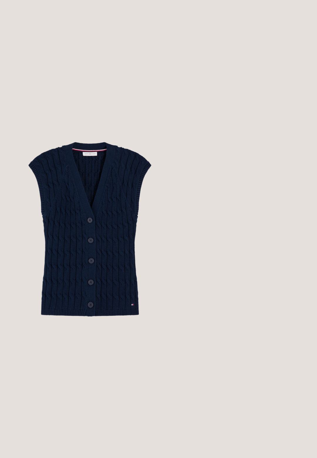 Marineblauwe mouwloze kabelgebreide cardigan-vest met vijf knopen aan de voorkant en een klein Tommy Hilfiger-logo bij de zoom.; Marineblauw-wit gestreept poloshirt met lange mouwen, een witte kraag en vijf gouden knopen aan de voorkant. Gemaakt van een katoenmengsel met een gladde textuur.; Marineblauwe geplooide rok met een gestructureerde stof, hoge tailleband en twee gouden knopen aan de voorkant, wat zorgt voor een strakke lijn en een gestructureerde vorm.; Donkerblauwe suède loafer met zwarte zool en lage hak, voorzien van een getoogde band en een klein gouden decoratief embleem bovenop.; Marineblauwe handtas met bruine leren handvatten, gouden beslag, een afneembare schouderband en een klein gouden logo in het midden.; Een paar zilveren oorringen, elk met drie kleinere gekoppelde ringen en een rood-wit-blauwe streep detail op de hoofdring.