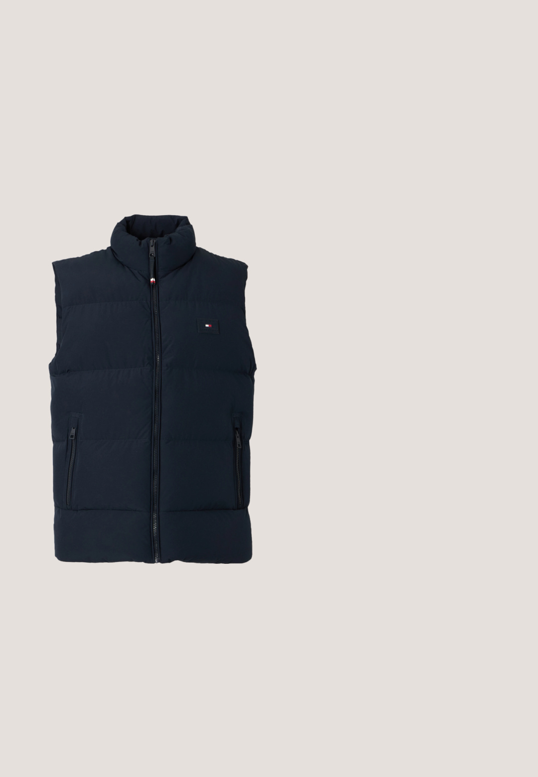 Veste sans manches matelassée bleu foncé avec fermeture éclair devant, col montant, deux poches zippées et petit logo rectangulaire sur la poitrine.; Sweat-shirt bleu marine à manches longues avec col rond et petit logo blanc Tommy Hilfiger sur la poitrine gauche.; T-shirt bleu marine à manches courtes et col rond avec un logo rectangulaire blanc comprenant la lettre "L" sur le côté gauche de la poitrine.; Jean en denim bleu taille haute avec une coupe droite et un design classique à cinq poches, sur fond blanc uni.; Sneaker en daim navy avec semelle en caoutchouc blanc, bout arrondi et languette de talon contrastante ; présente des lacets ton sur ton et un détail de logo sur le côté.; Sac fourre-tout en toile blanche avec des accents bleu marine. Dispose de deux poignées robustes et d'un écusson logo à l'avant. Forme rectangulaire.