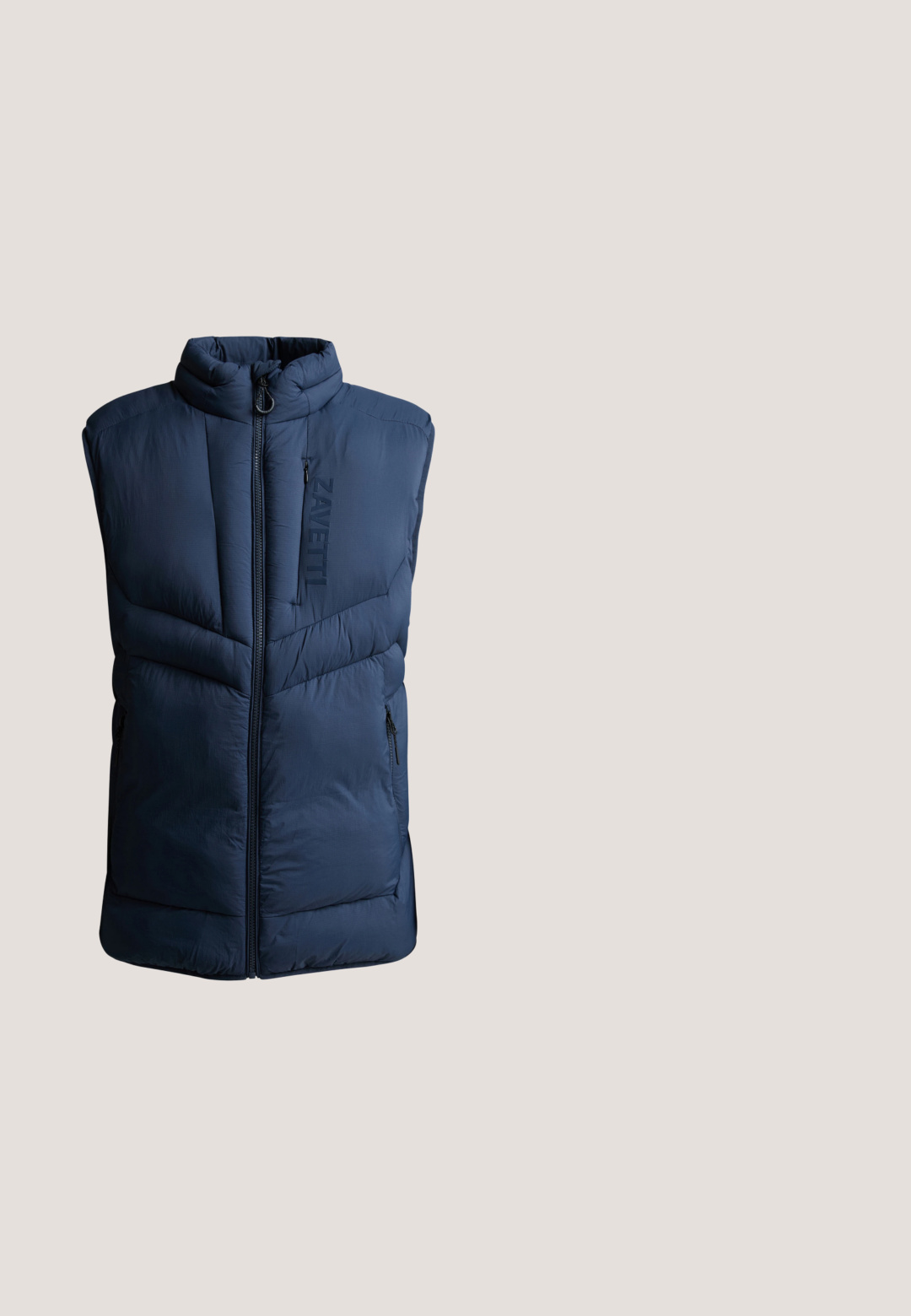 Chaleco acolchado sin mangas azul marino con cremallera frontal y bolsillos con cremallera en el pecho y los laterales, con texto vertical "ZAVETTI" en el pecho.; Sudadera azul marino hecha de tejido suave, con cuello redondo, puños acanalados y un pequeño logo blanco en el pecho.; Camiseta azul marino de manga corta con cuello redondo y pequeño texto blanco "GUESS EST. 1981" en el pecho izquierdo.; Pantalones deportivos azul oscuro hechos de mezcla de algodón, con cintura elástica con cordón y puños en los tobillos. Detalle de pequeño logo amarillo.; Zapatilla azul y gris con parte superior de malla y material sintético, superposiciones estructuradas, suela blanca gruesa y sistema de cordones. Logo visible en el lateral.; Bolso bandolera rectangular azul marino con dos compartimentos con cremallera y un logo triangular plateado de Guess en el bolsillo delantero.