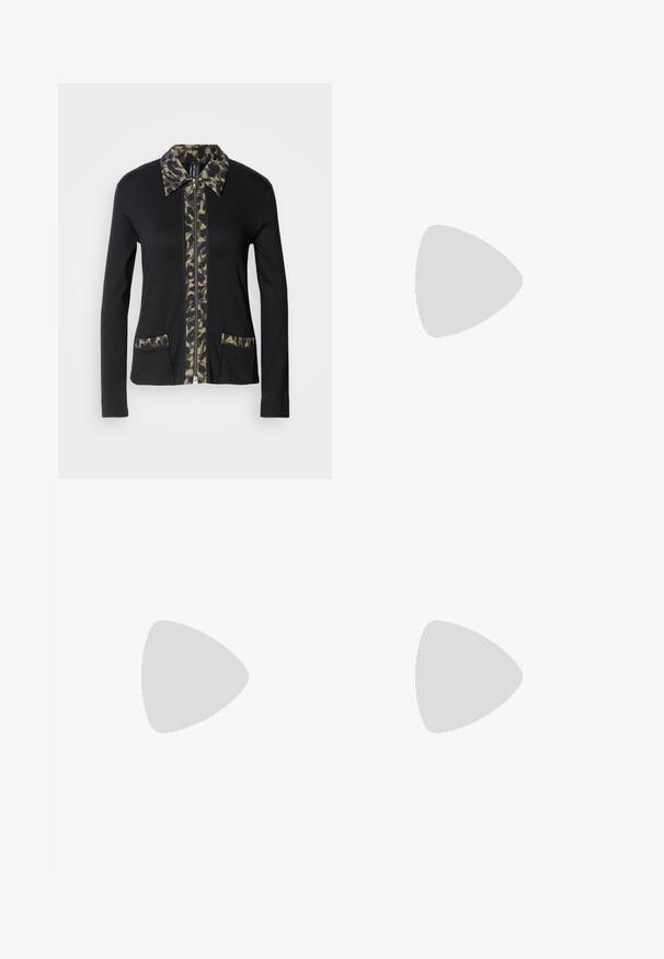 Zwarte zip-up jas met een kraag en voorpaneel in camouflagepatroon, voorzien van twee voorzakken met bijpassende details. Lange mouwen.; AllSaints LISA TEE - T-shirt basic - black; Lichtblauwe wijd-uitlopende jeans van denim, met een hoge taille, sluiting met voorknop en zichtbare stiksels op de zakken en naden.; Zwarte leren enkellaars met puntige neus en lage hak, afgebeeld tegen een glazen blokkenmuur en gepolijste vloer op de achtergrond.