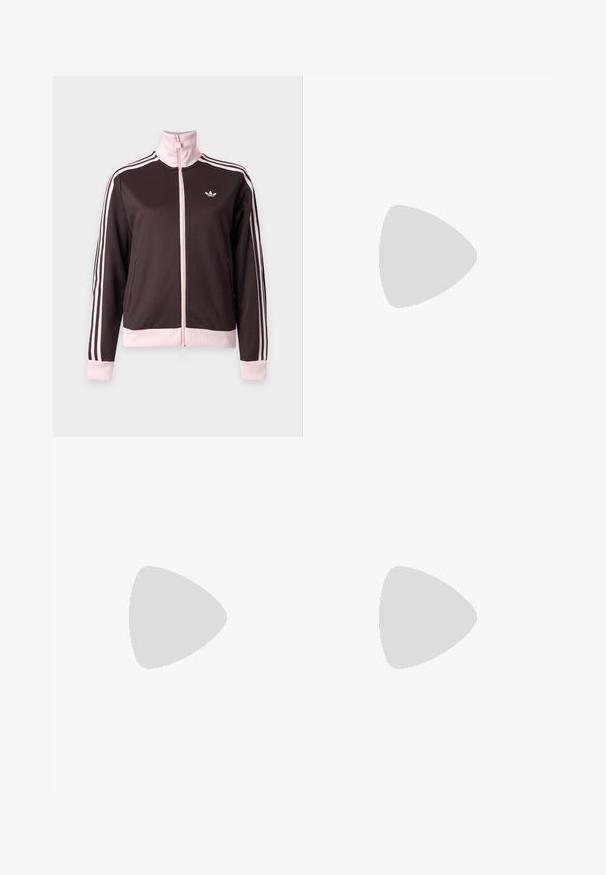 Donkerbruine jas met ritssluiting, lichtroze kraag, manchetten, zoom en drie strepen op de mouwen, met een klein logo op de borst.; Witte mouwloze crop top met ronde hals en klein zwart Adidas trefoil-logo, gecentreerd onder de kraag.; Lichtgrijze sweatpants met een losse pasvorm, elastische tailleband en zachte textuur. Heeft subtiele branding aan één kant. Casual ontwerp.; Benen met geribbelde lavendelkleurige sokken met witte kruisbanden, gecombineerd met witte ballerina's met zwarte bies op een groene vloer.