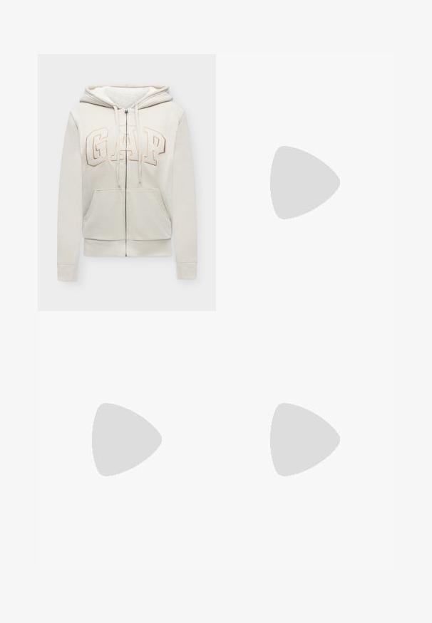 Beige zip-up hoodie met voorzakken, trekkoord in de capuchon en het "GAP"-logo in grote letters op de borst geborduurd.; Mouwloze lichtbeige ribgebreide tanktop met een ronde halslijn en een aansluitende pasvorm. Gemaakt van zacht katoen.; Zwarte sweatpants met brede pijpen, een elastische tailleband en een trekkoord. Gemaakt van zacht katoen, met vooraan naden voor extra detail.; Beige lage sneakers met een glanzende afwerking, uitgerust met een gestructureerde rubberen zool, een ronde neus en zes oogjes voor de veters.