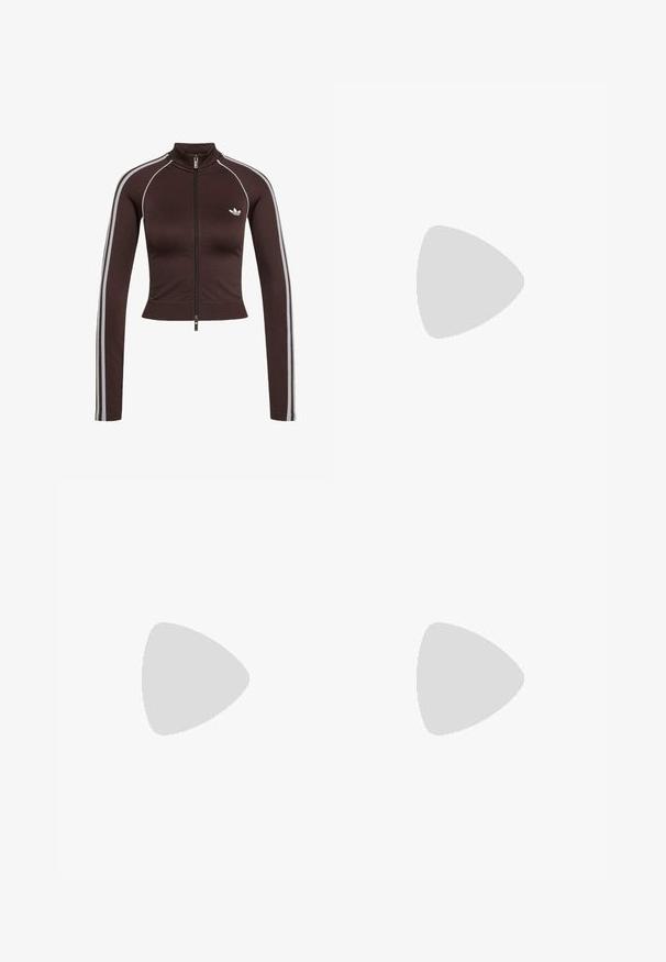 Mørkebrun cropped træningsjakke med forlynlås, høj krave, hvide sidelstriber på ærmerne og lille hvid Adidas-logo på brystet.; Brun ribstrikket cropped top med korte ærmer, rund halsudskæring og en tekstureret kant forneden med et diskret logo-mønster.; Marine atletikshorts lavet af letvægtsmateriale, med hvide sidelister og et broderet logo nederst til venstre. Elastisk talje.; Sort Adidas sneaker med hvide striber og beige sål, fanget i luften over en stenet overflade og baggrund af en stenmur.