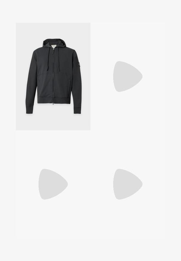 Schwarzer Hoodie mit Reißverschluss, Fronttaschen, Kordelzugkapuze und kleinem Aufnäher am linken Ärmel vor schlichten Hintergrund.; Schwarzes T-Shirt mit kurzen Ärmeln und Rundhalsausschnitt mit kleinem weißen "cK" Logo auf der linken Brust und Calvin Klein Jeans Label innen im Kragen.; Schwarze Jogginghosen aus leichtem Stoff, mit einem elastischen Bund und verstellbaren Kordeln sowie Seitentaschen. Glatte Textur.; Schwarzer Ledersneaker mit Schnürsenkeln und seitlichem Reißverschluss, getragen mit weißen Socken und brauner Hose, Fuß ruht auf der Fußstütze eines Rollstuhls.