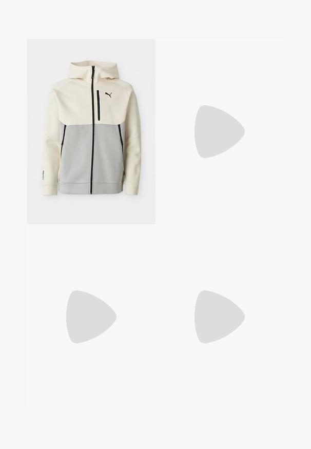 Chaqueta con capucha de Puma que presenta una parte superior en crema y una sección inferior en gris, con cierre frontal, dos bolsillos y detalles del logo en negro.; Camiseta de algodón negra con un estampado gráfico que incluye elementos de texto, como "FORMULA 1 RACING" y "P1". Cuello redondo y mangas cortas.; Pantalones de chándal negros con cintura elástica y cordón, con bolsillos laterales y un sutil logo en la pierna izquierda. Tela suave, forma acampanada.; Zapatilla Puma de perfil bajo en negro con franja lateral beige, cordones negros y suela de goma, mostrando el lado exterior izquierdo con la marca "Puma Tackle".