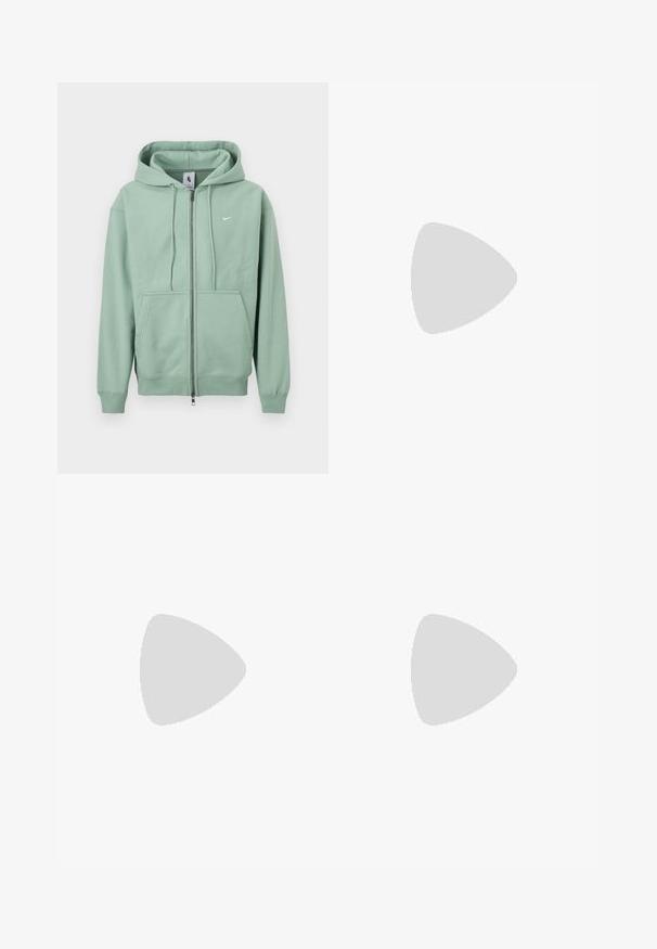 Sweat à capuche zippé Nike vert menthe avec cordon de serrage, poches kangourou à l'avant et petit logo blanc sur la poitrine.; T-shirt noir à manches courtes avec un cactus cartoon vert et le texte blanc "Conditions Gear Big Bend, Texas" sur la poitrine gauche.; Shorts en denim gris délavé à taille haute, avec poches avant, passants pour ceinture, fermeture par bouton et texture subtilement froissée.; Baskets athlétiques noires avec une semelle intercalaire à coussin d’air visible flottant au-dessus d’une surface en pierre rose avec un mur en pierre gris en arrière-plan.