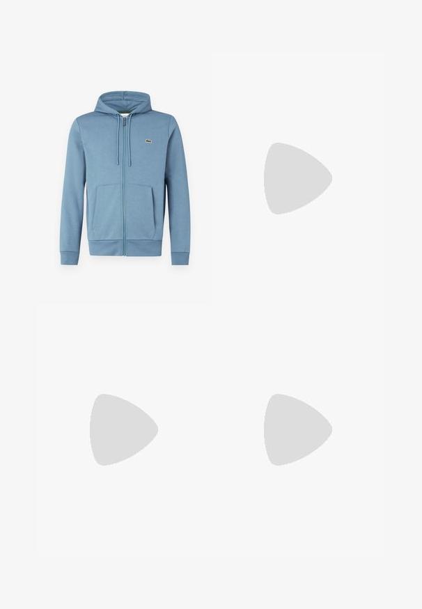 Lyseblå zip-up hoodie lavet af blødt stof. Har en hætte med snore, forlommer og et brandlogo på brystet.; Hvid bomulds T-shirt med V-hals, korte ærmer og et lille grønt krokodillelogo på venstre bryst. Simpelt og let design.; Mørkeblå joggingbukser lavet af bomuldsblanding, med elastisk taljebånd med snøre og manchetter ved anklerne. Lille gul logo detalje.; Hvid lav Lacoste sneaker med snørebånd, præget logo på siden og tekstureret sål på en ensfarvet baggrund.
