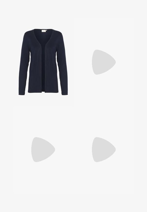 Kaffe KAFENIA ASTRID - Vest - midnight marine; Lichte beige top met een ronde halslijn, asymmetrische zoom en geplooide details aan één kant. Gemaakt van een zachte, gestructureerde stof.; Donkerblauwe denim jeans met een slim fit, vijf-pocket ontwerp en knoopsluiting. Heeft subtiele vervaging en gestikte accenten in contrastkleur.; Witte Adidas-sneaker met zwarte strepen, bruine gestructureerde zool en gouden "SPEZIAL"-letters aan de zijkant, gezien vanaf de buitenkant.