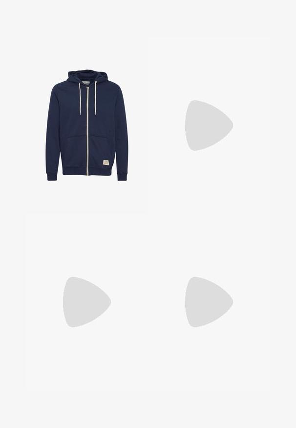 Marineblaue Kapuzenjacke mit Reißverschluss, weißen Kordeln, Fronttaschen, gerippten Bündchen und einem kleinen beigen Markenetikett am unteren vorderen Saum.; Graues Baumwoll-T-Shirt mit Rundhalsausschnitt, kurzen Ärmeln, geradem Saum und einer weichen Textur; minimales Branding ist am Ausschnitt sichtbar.; Dunkelblaue Denim-Jeans mit geradem Bein, fünf Taschen, goldenen Nähten und einer glatten Textur. Knopfverschluss an der Taille.; Weiße Nike Air Max 90 Sneaker mit einem Obermaterial aus Mesh und Leder, durchlässigem Zehenbereich und einer sichtbaren Air-Einheit in der Ferse.