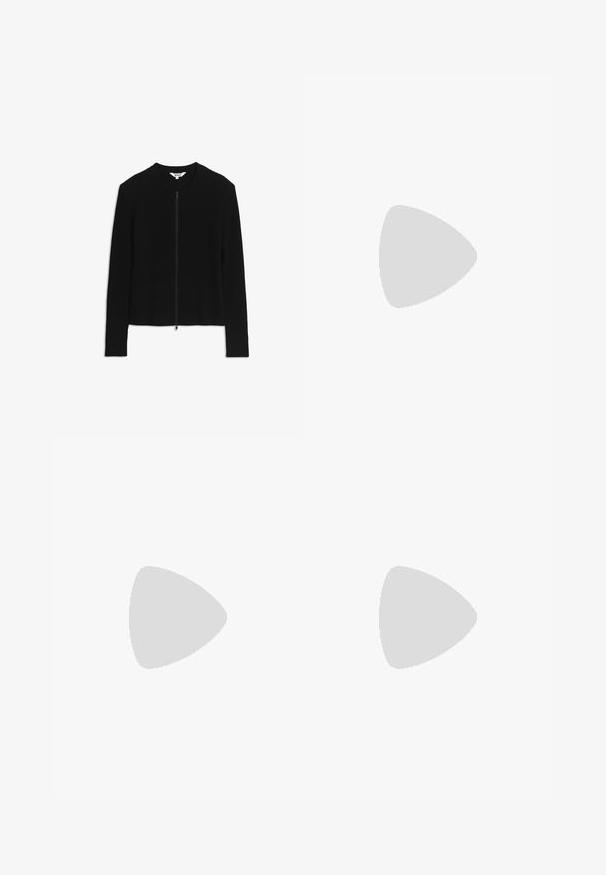 Cardigan noir côtelé à manches longues avec fermeture éclair devant et encolure ronde, taille small, posé à plat sur un fond blanc.; T-shirt blanc uni à manches longues et col rond, posé à plat sur une surface blanche, montrant l'avant et la longueur complète des manches.; Pantalons larges beiges en coton, dotés de deux poches avant, de boutons doubles à la taille et d'un design sans embellissement.; Baskets blanches avec des bandes noires et une semelle en gomme flottant au-dessus d’escaliers en béton dans une lumière douce du jour.